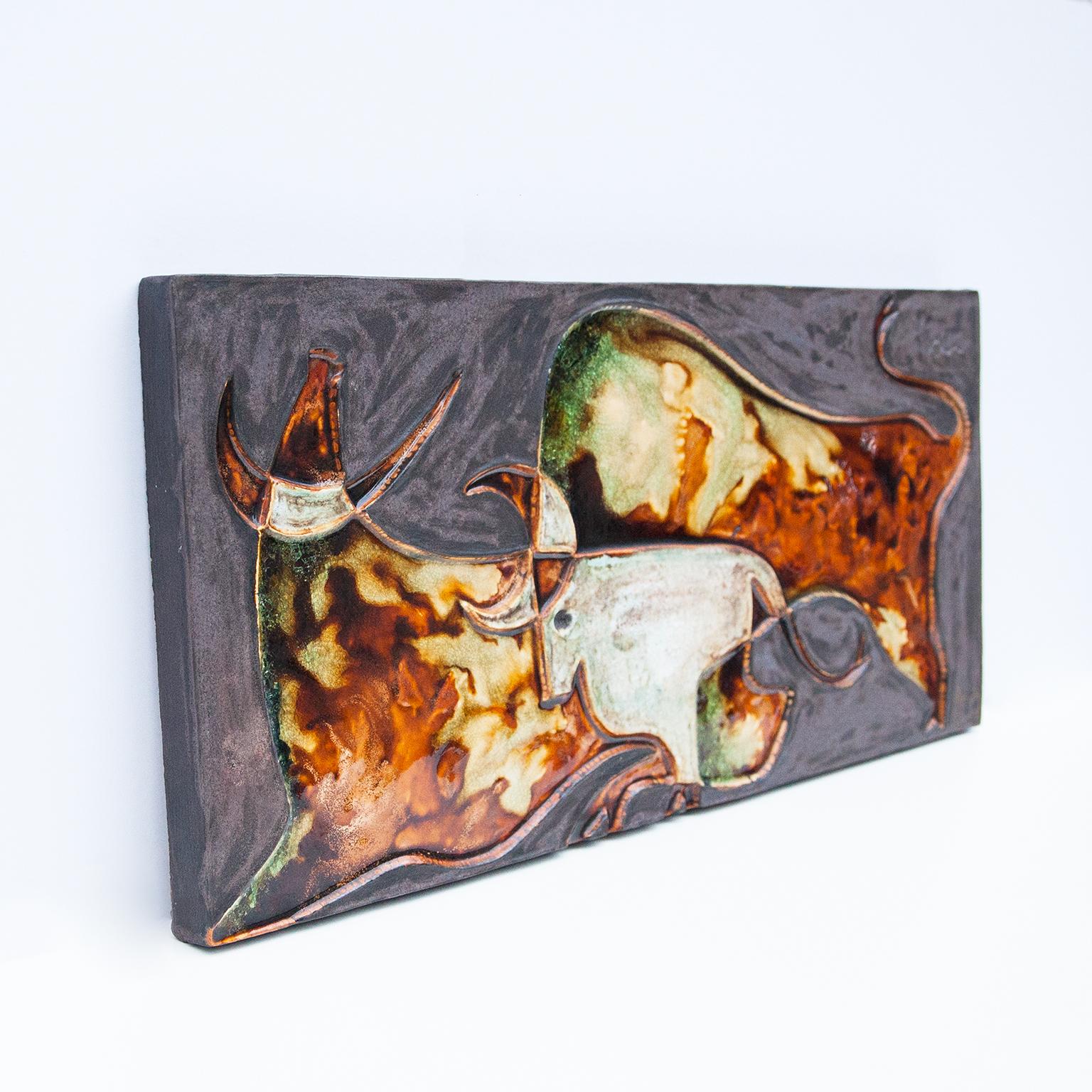 The unique wall panel is made with three bulls in grey, green brown ceramic in Jean Miro Style, designed by Helmut Schäffenacker German art pottery / studio in 1960s. Wonderful object in deep colors and a unique piece with artist mark. Helmut
