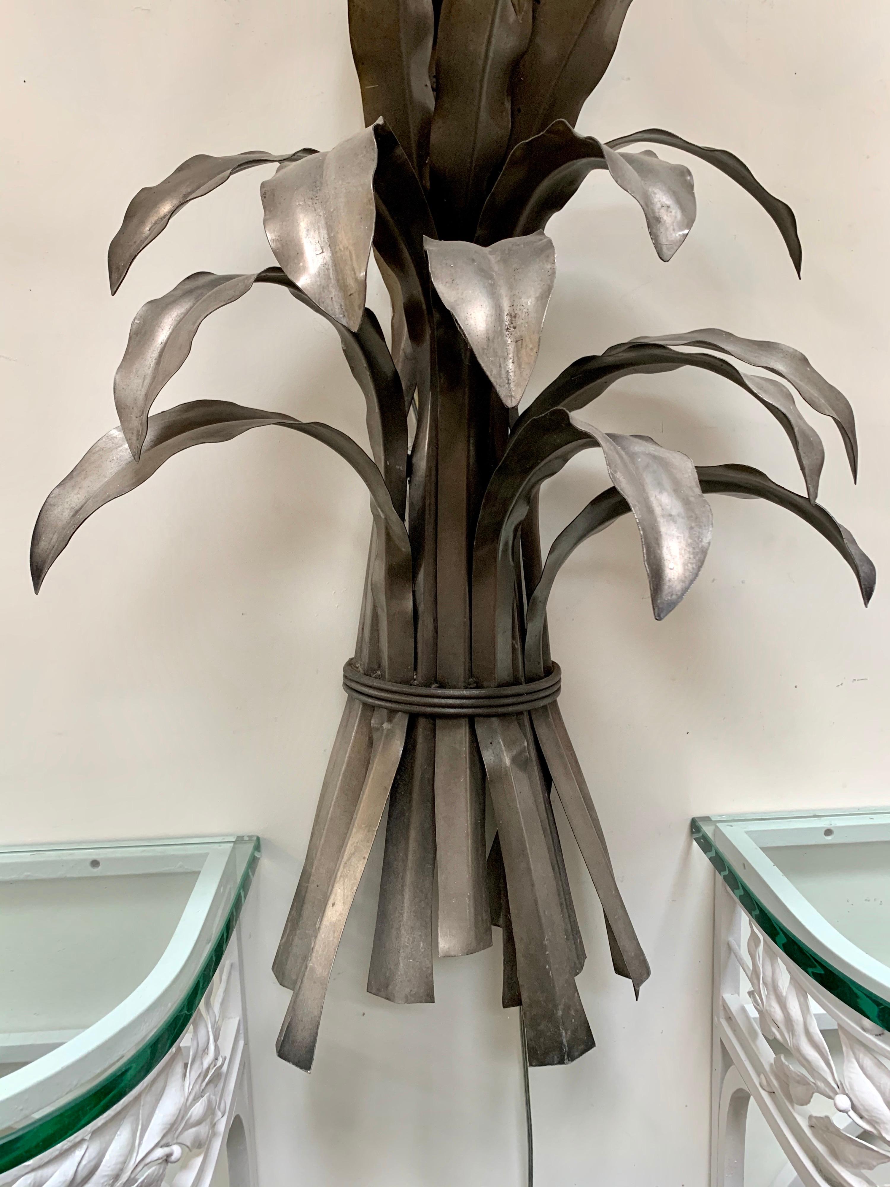 Stunning and unusual extra large Hollywood Regency silver palm tree sconce that measures seventy-five inches tall. It features three working lights at top. Wired for USA and in perfect working order. Note we are also selling the pair of these in a