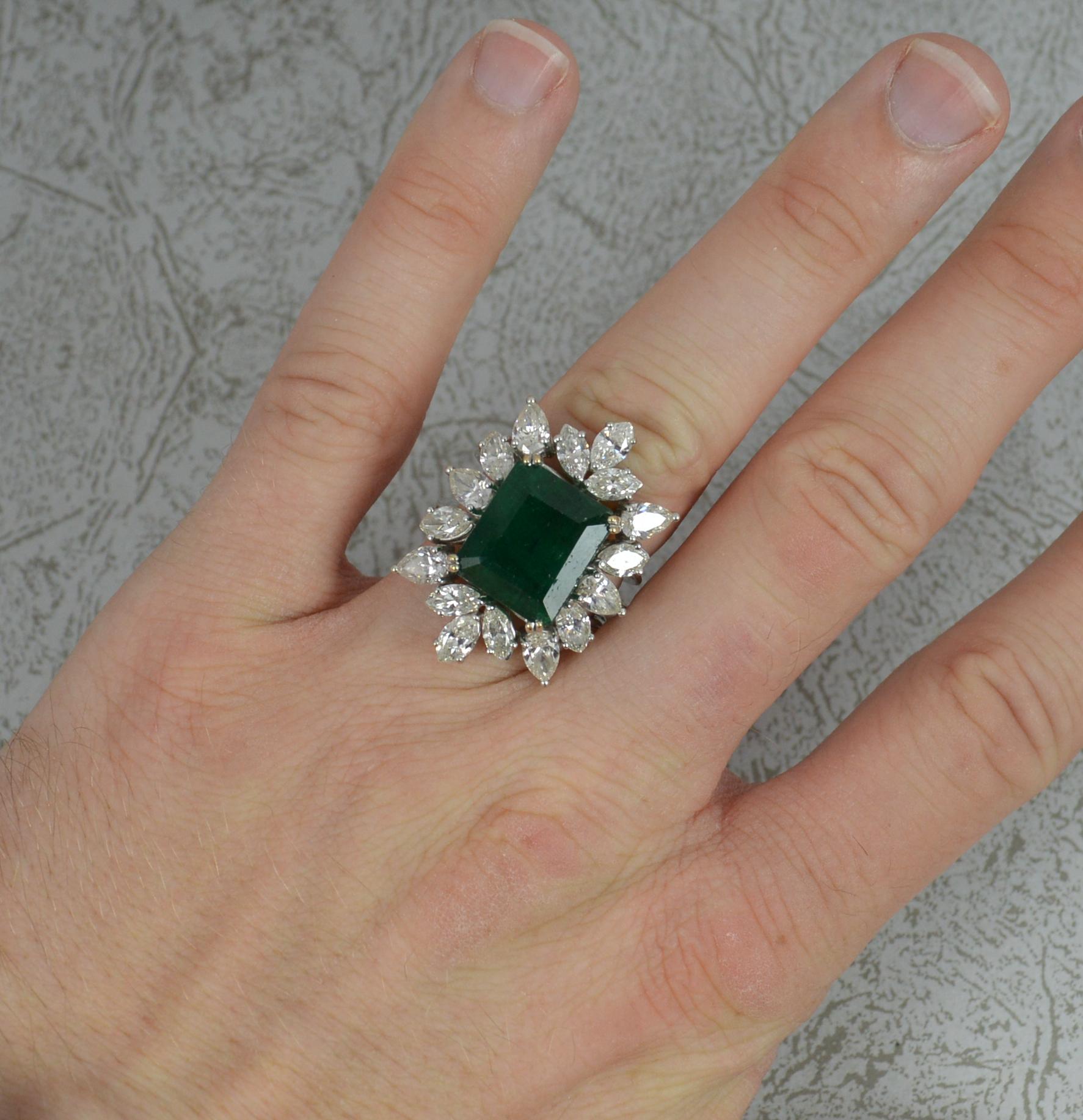 A fantastic Emerald and Diamond cluster ring.
A solid 18 carat white gold shank.
Designed with a large emerald cut emerald to centre in four claw setting. 11mm x 12.9mm. A natural emerald of deep dark green colour.
Surrounding are six pear cut and