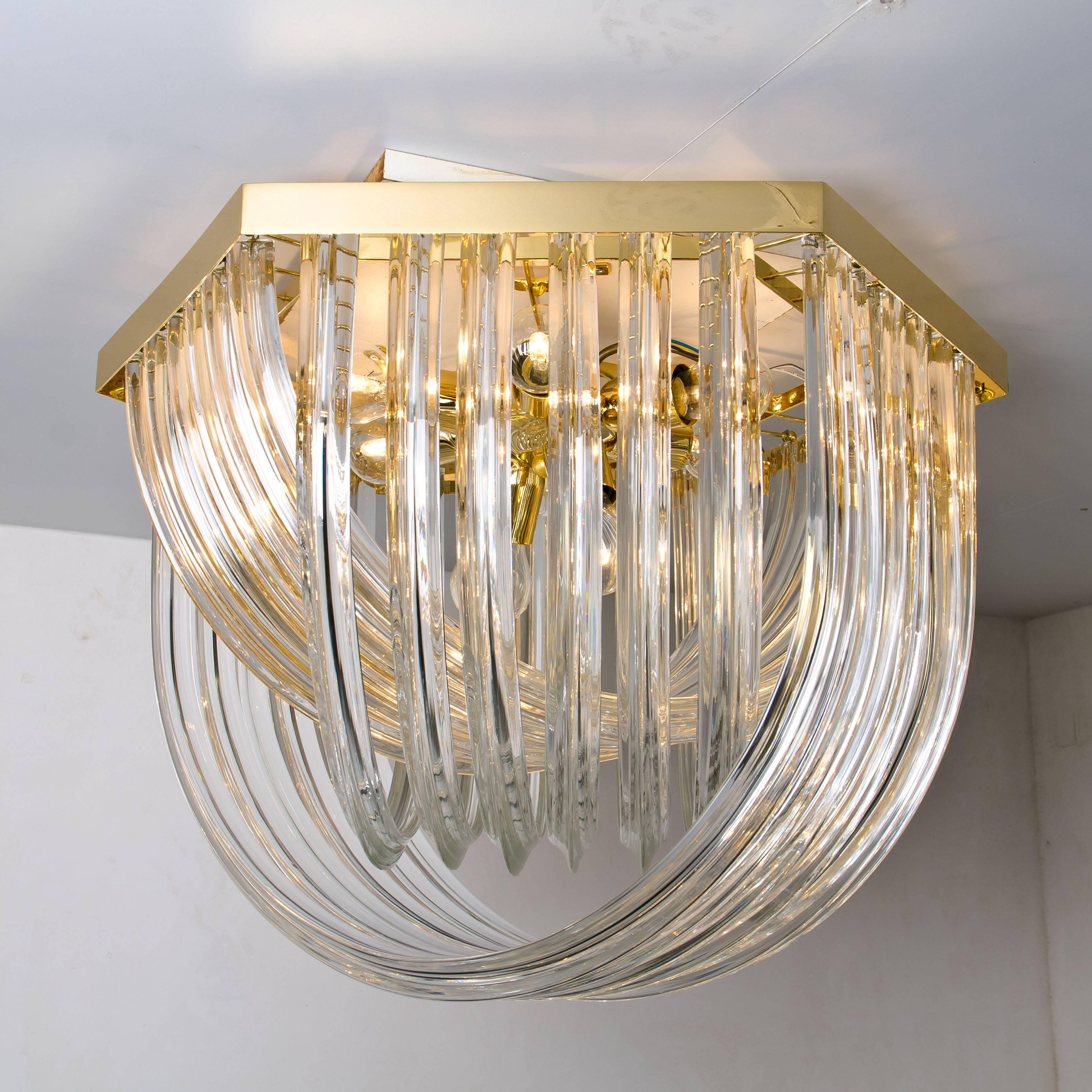 A huge and impressive Venini flushmount chandelier, curved crystal glass and gilt brass, Italy.

The chandelier is made of curved crystal Murano glasses in different lengths. The flushmount has eight lights with 18 Murano crystal tubes and a