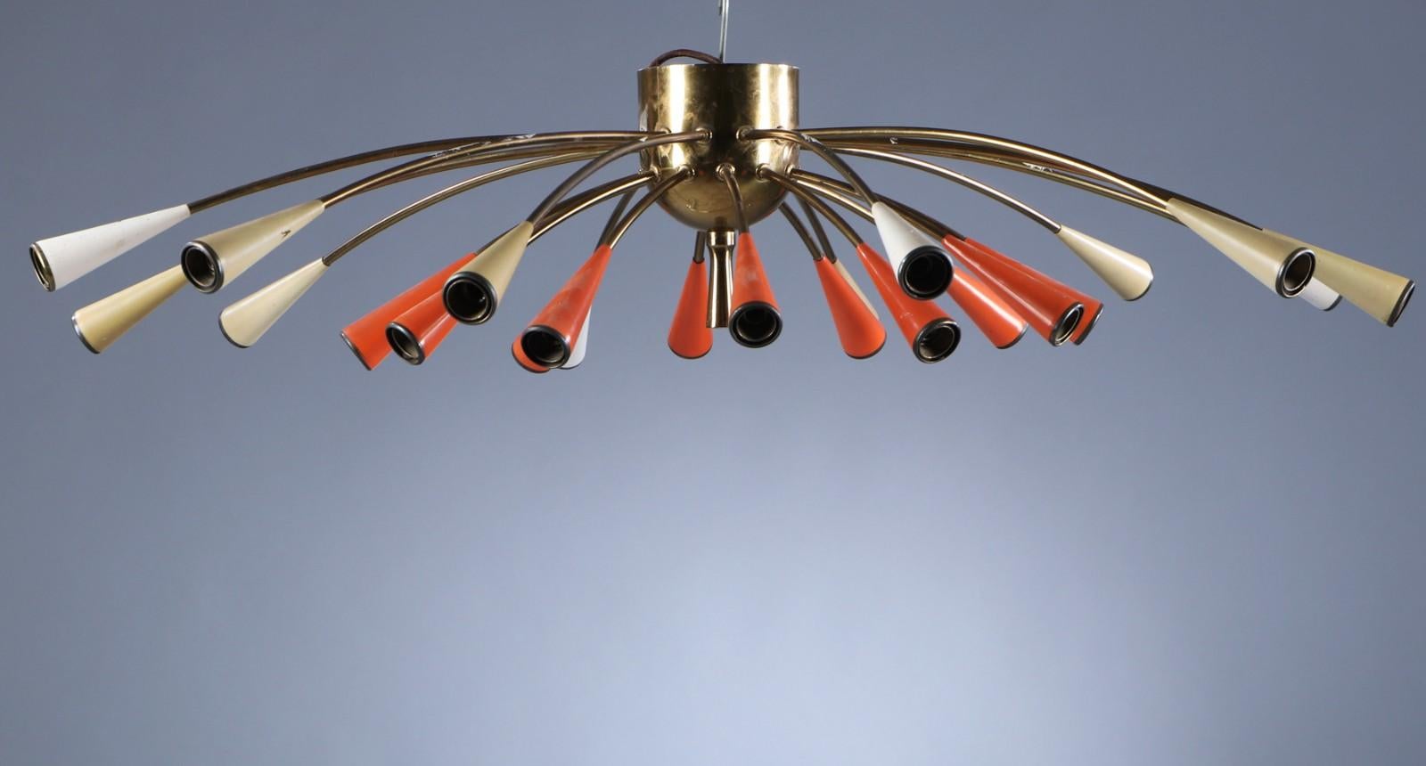 Italian lamp manufacturer 1950s. Brass ceiling lamp with twelve larger and twelve smaller light arms with conical shades of white and orange-colored metal. Ø. 105 cm. 
Original condition, rewired for european use.
 