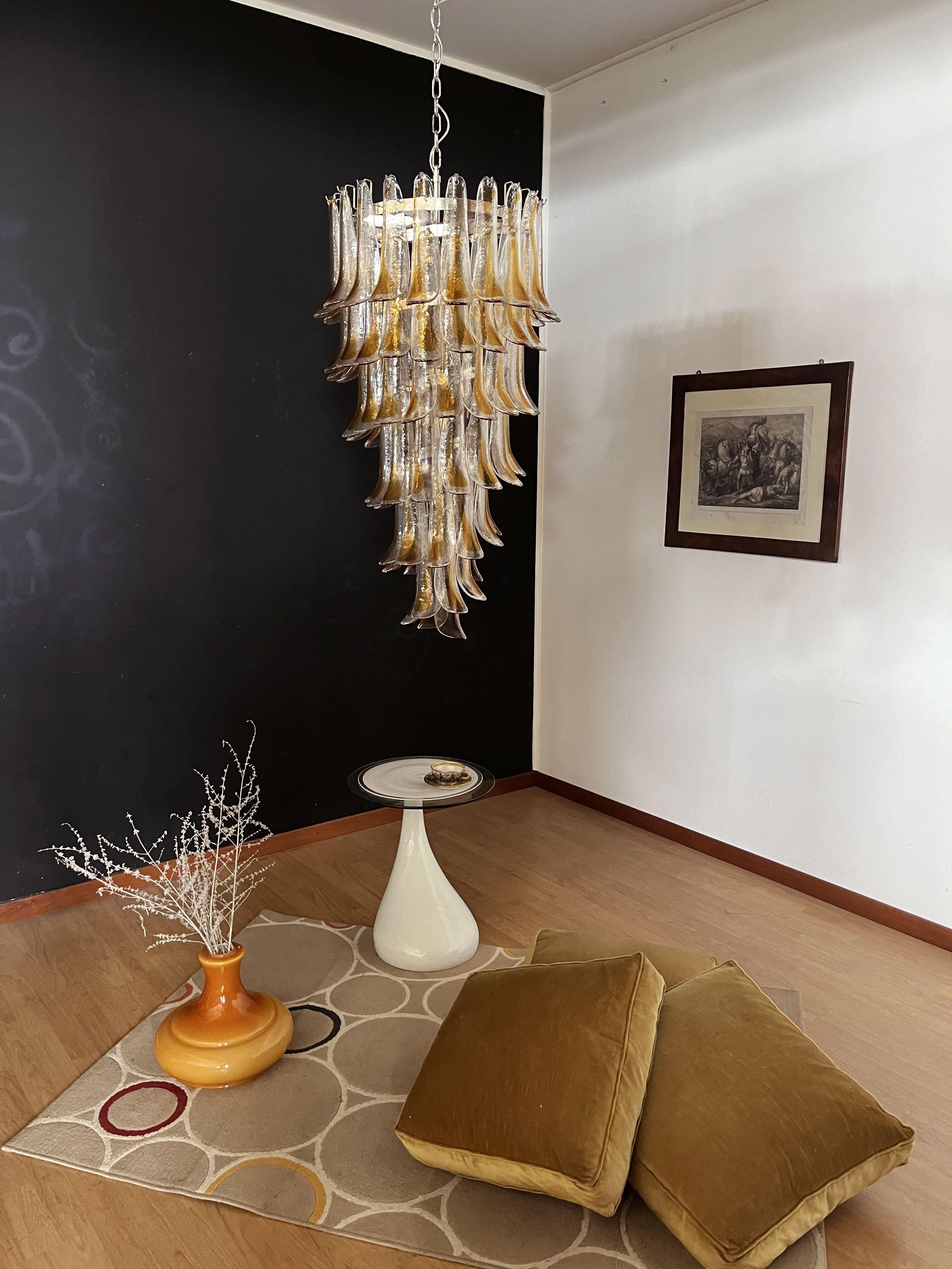 Beautiful and huge Italian Murano chandelier composed of 83 splendid glass petals (clear with amber spot) that give a very elegant look. The glasses of this chandelier are real works of art. The glasses descend with a spiral shape.
Dimensions: