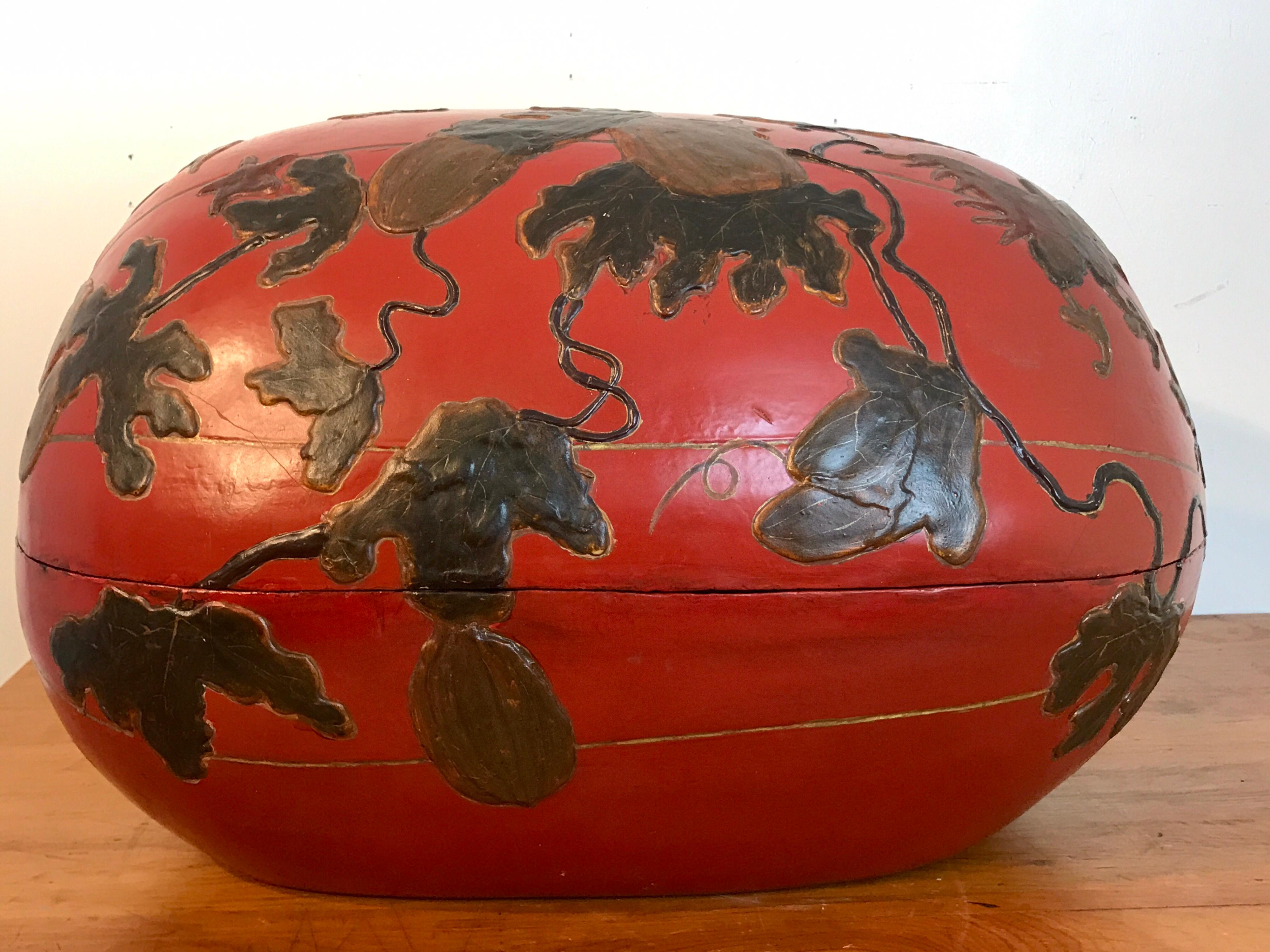 Huge Japanese red lacquerware gourd motif box, decorated in relief with Japanese gourds suspended from leafy branches and scrolling vines.