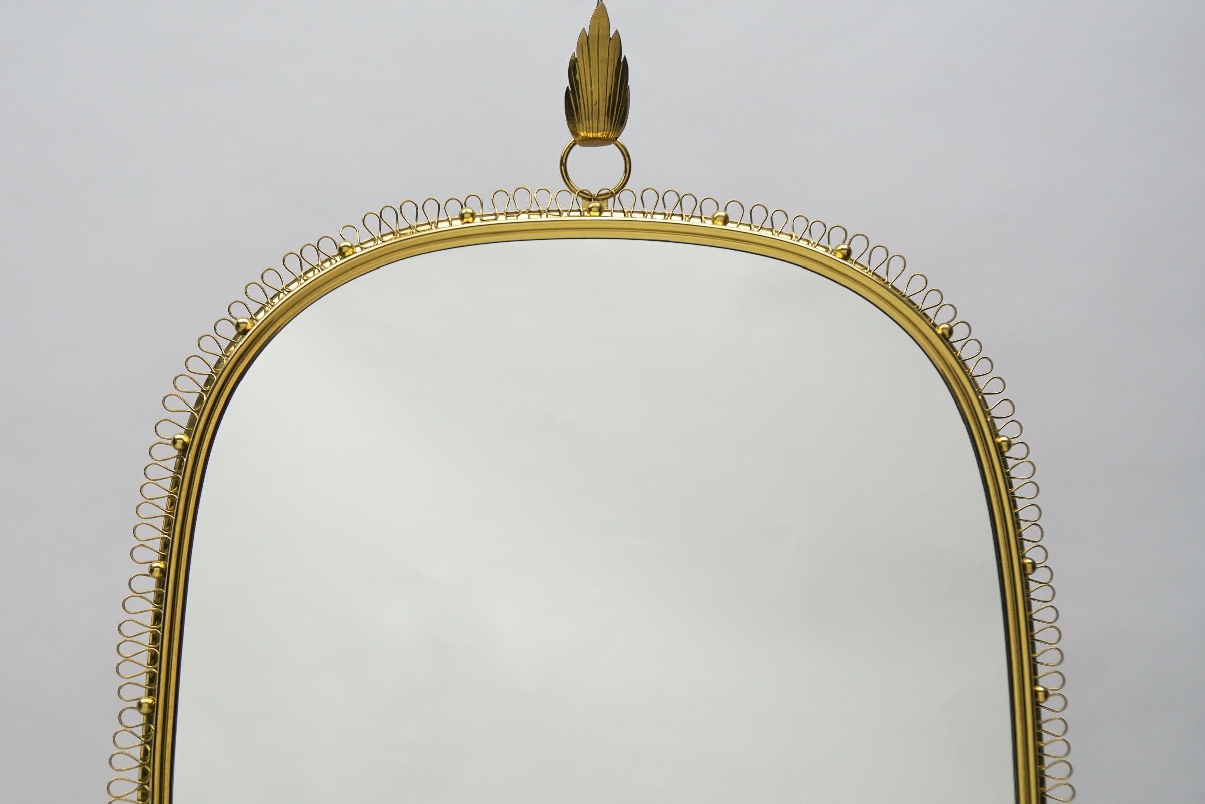 Mirror by Josef Frank for Svenskt Tenn from the 1950s. Golden color, in brass and glass.

The mirror without the leaf hook is Height: 41.34 in (105 cm), Width: 27.56 in (70 cm), Depth: 1.97 in (5 cm).