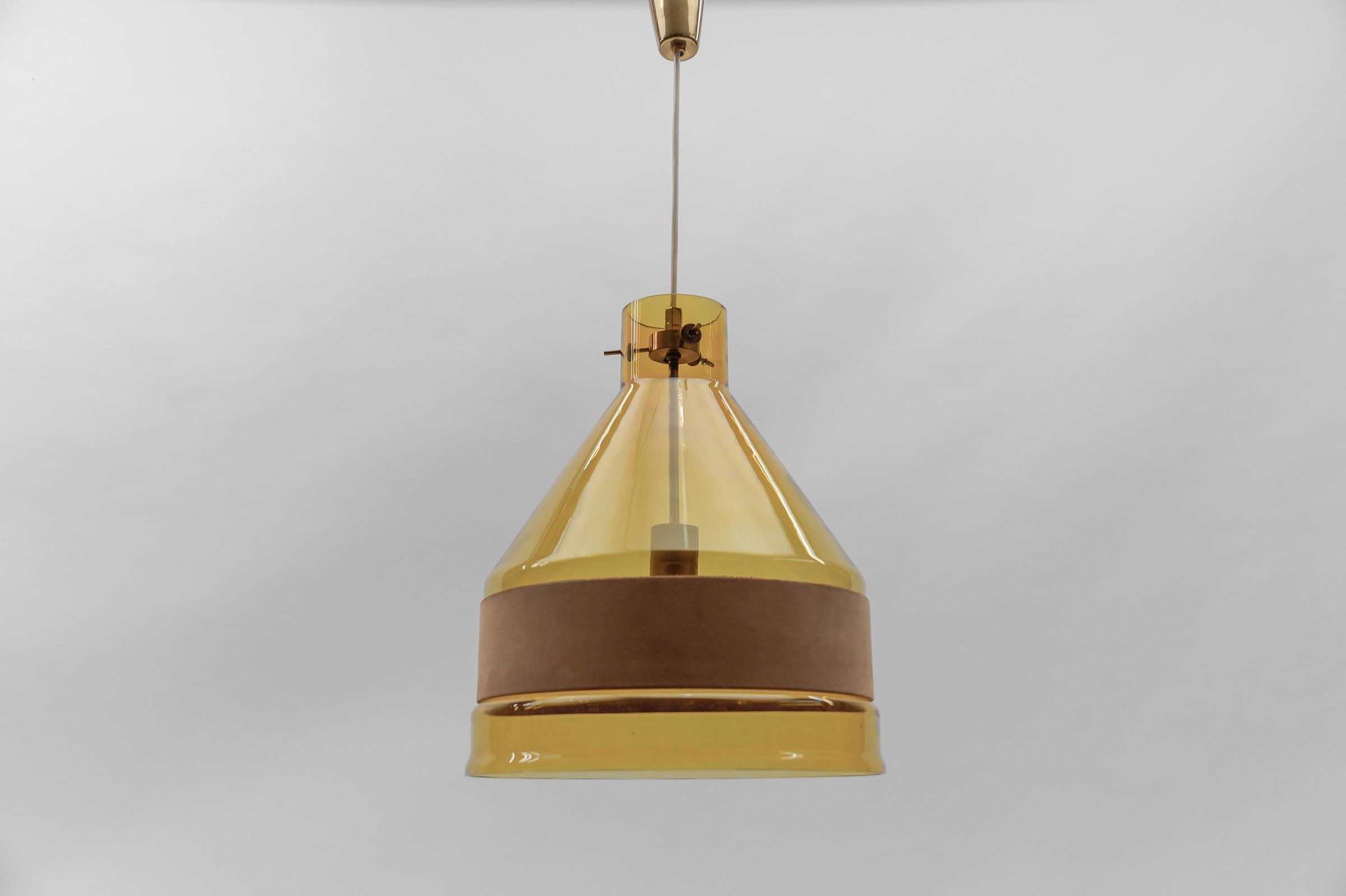 Rare J.T. Kalmar Yellow Tinted Glass Pendant Lamp with Leather, Austria 1970s

Dimensions
Height: 31.49 in. (80 cm)
Diameter: 14.56 in. (37 cm)

The lamp is executed with 1x E27 Edison screw fit bulb. It is wired and in working condition. It runs