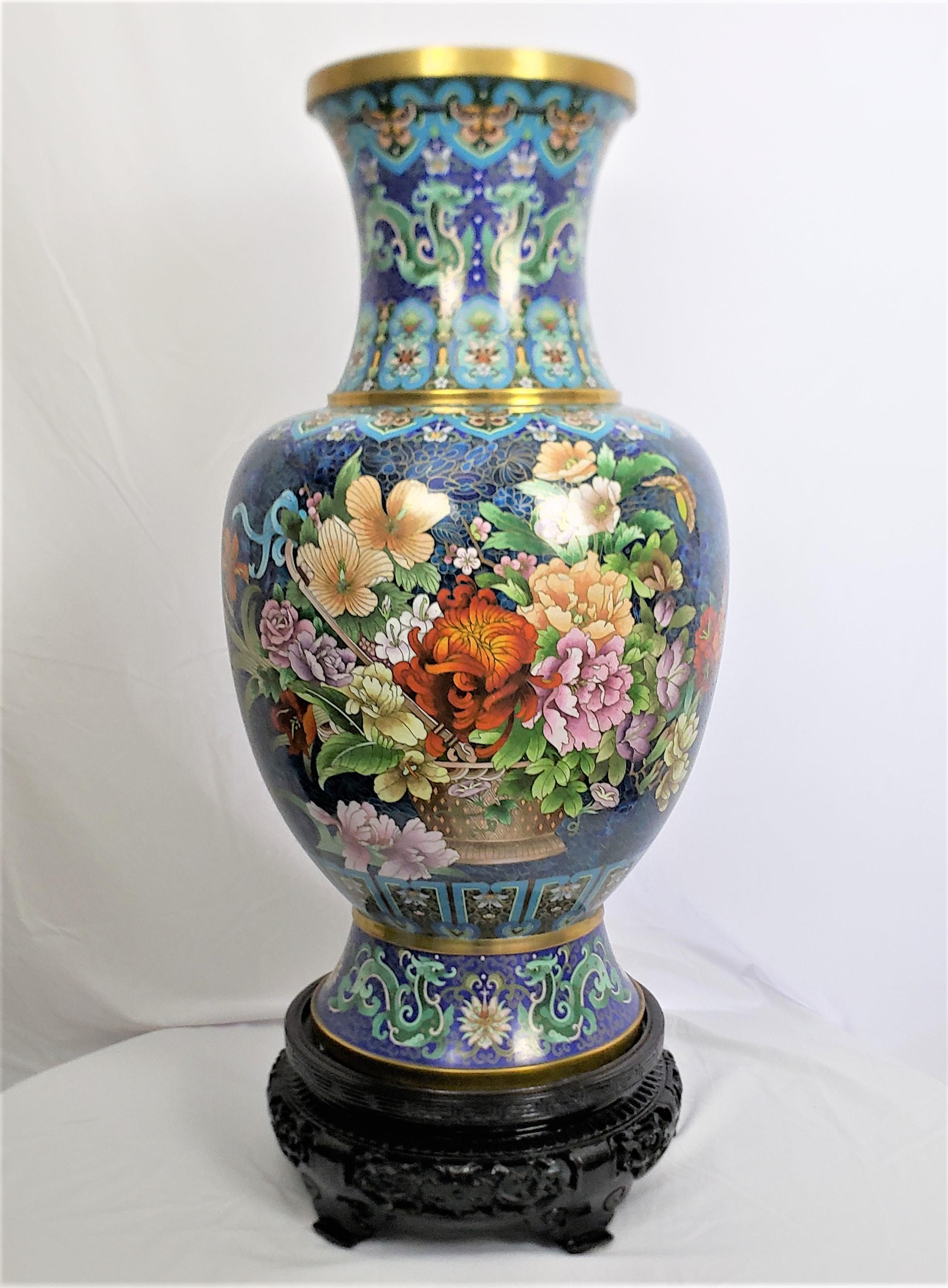 This extremely large and substantial cloisonne vase is unsigned, but presumed to have originated from China, and date to approximately 1970 and done in the period Chinese Export style. The vase is done with a cobalt blue ground with two very