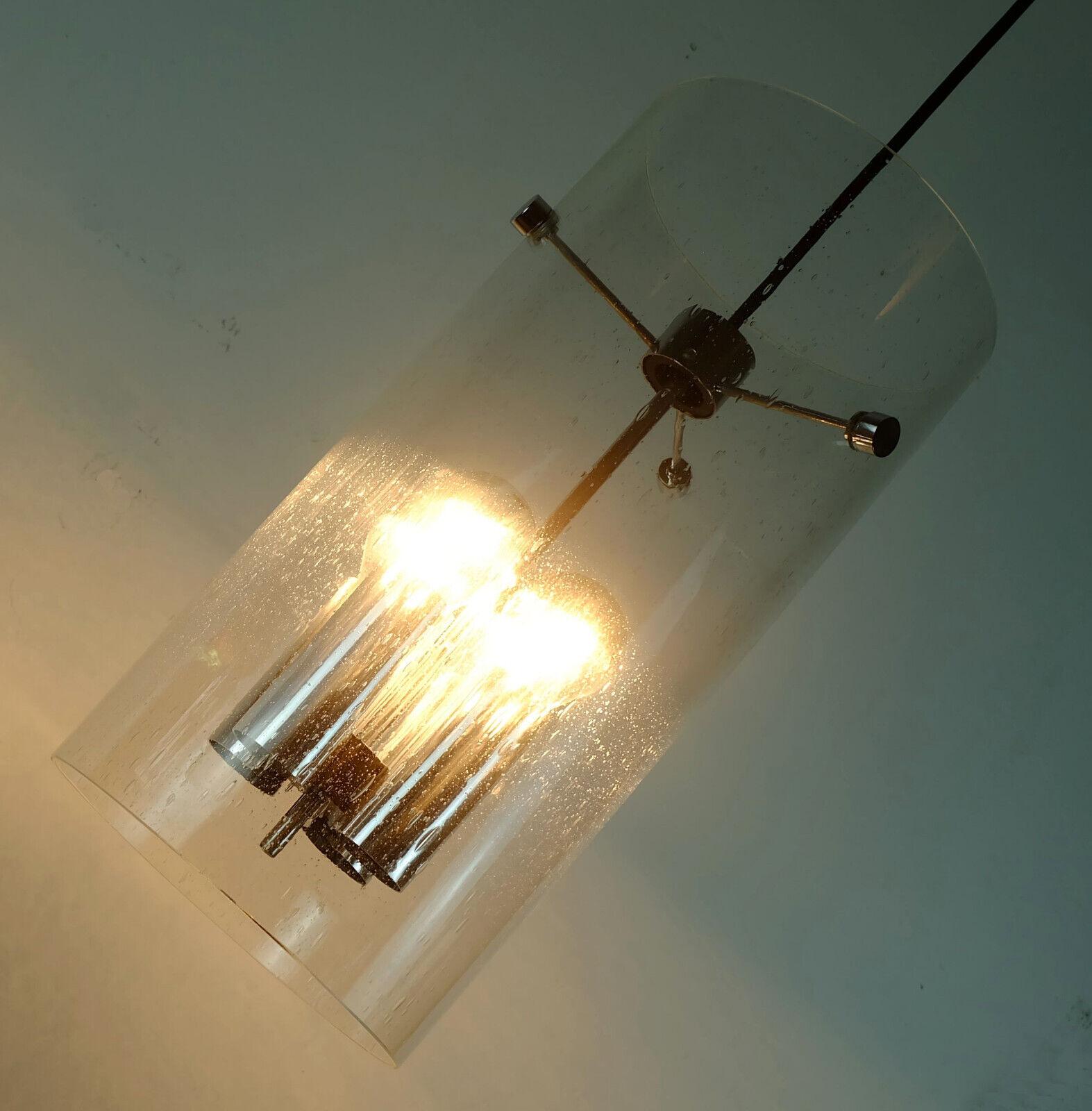 Midcentury pendant light manufactured in the 1970s by Glashuette Limburg. Model 4399. Transparent cylindrical glass shade with bubble structure, chrome details, black electric wire and canopy. Holds 4 E27 light bulbs.

Pre-used, good condition, no