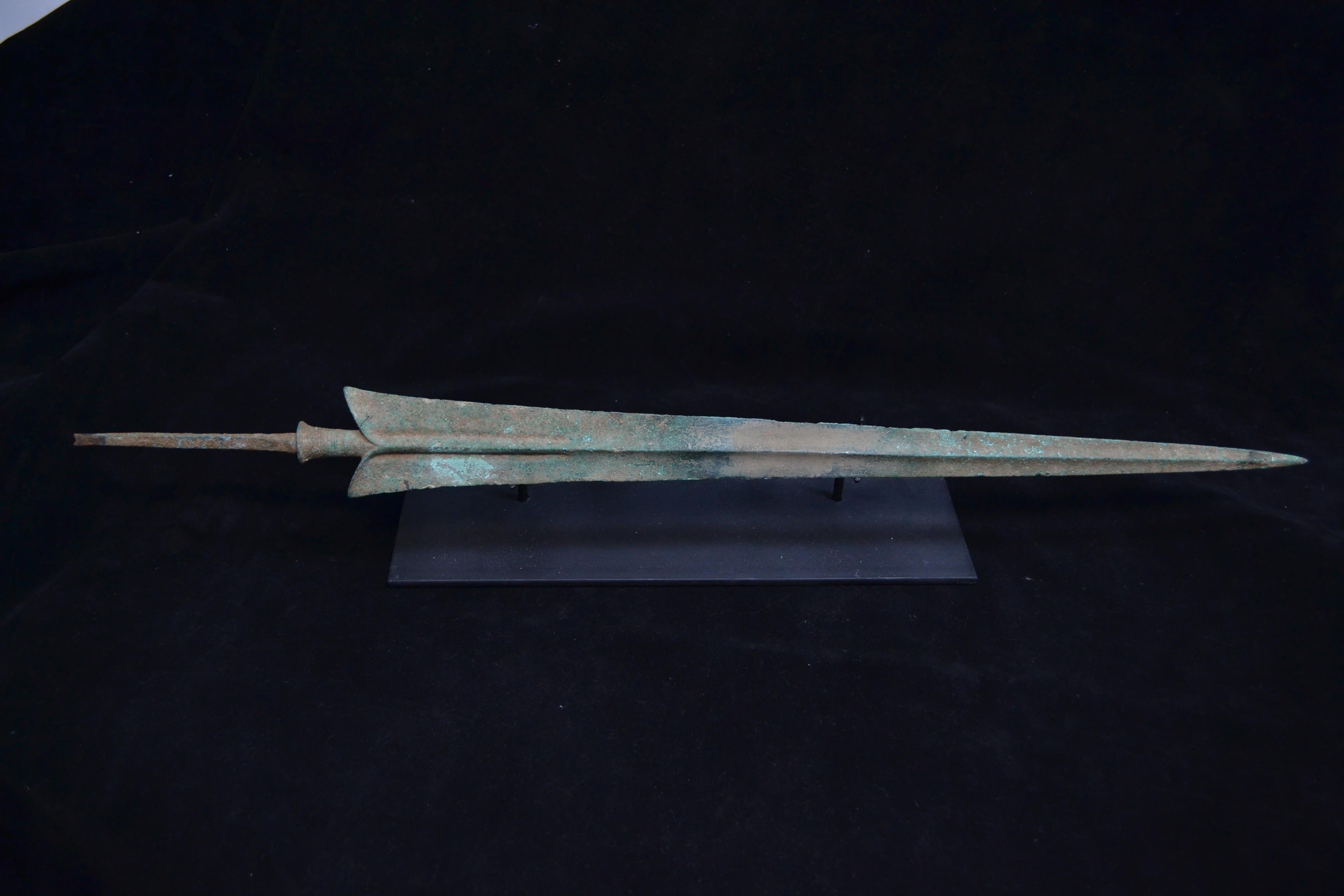 Impressive extra large bronze spearhead. Beautiful green patina, sign of its age. Minor chips at the edge of the blade commensurate with age, otherwise intact. This piece comes with a custom matte black stand and Certificate of