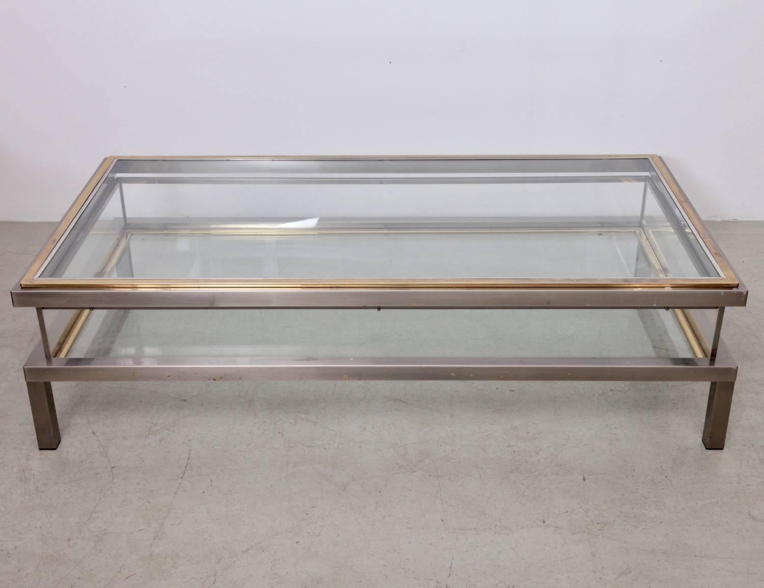 Länglicher Glastisch mit Schiebeplatte von Maison Jansen. Der Rahmen ist aus vergoldetem und verchromtem Metall gefertigt.

