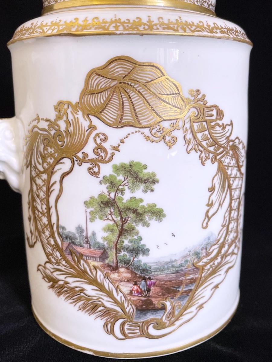 Huge Meissen Chocolate pot with a rich gilding and some very detailed polychrome painting of landscapes. Very intense colours.

The gilded silver mounting was made later in the late 19th century (please see hallmarks).

Underglaze swordsmark