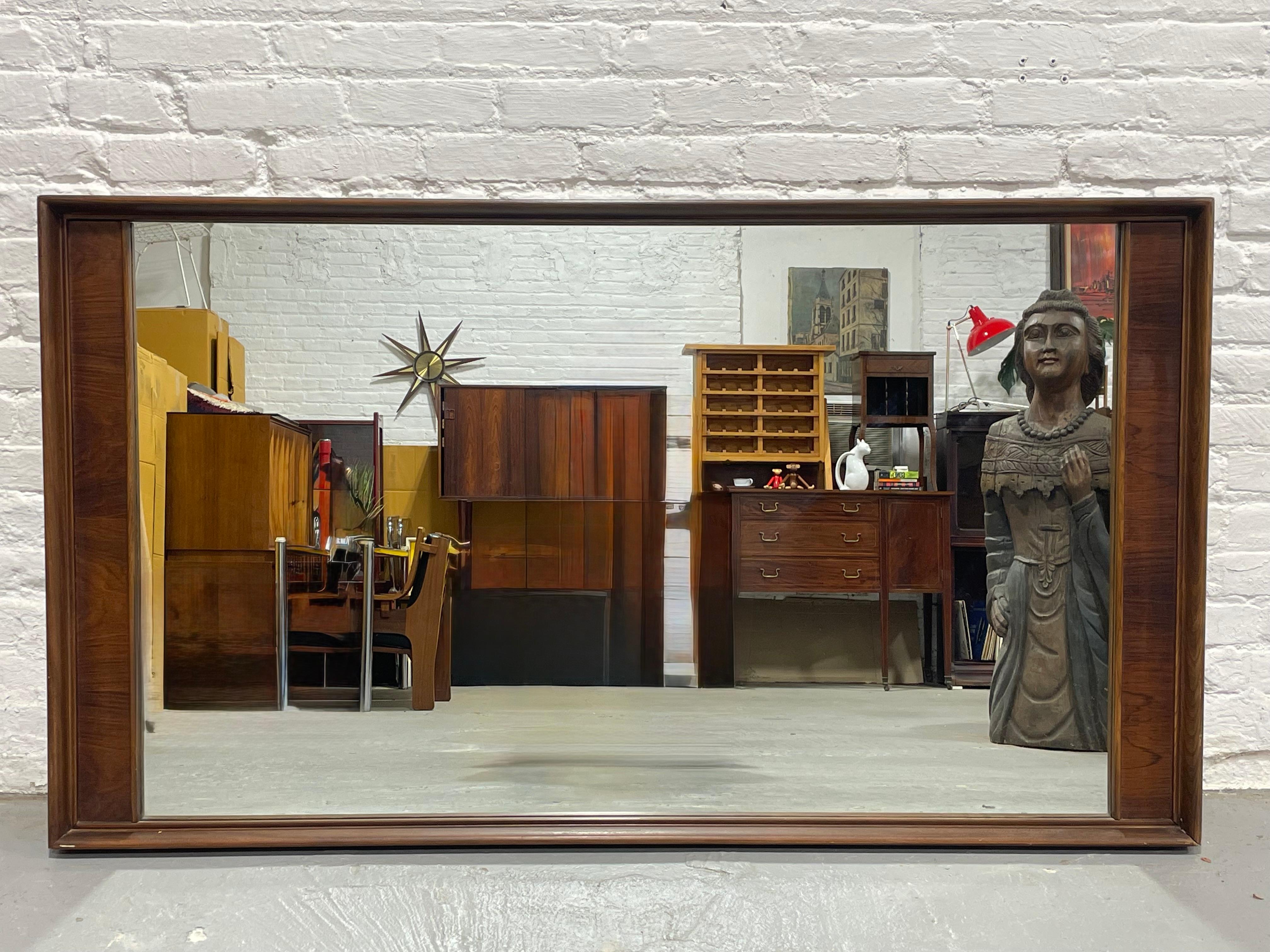 Huge Mid Century Modern Rosewood Mirror, circa 1960's. Lovely vintage condition with only light wear from age and use. There is hanging hardware in the back to hang the mirror horizontally but it can be changed if you want to hang it vertically