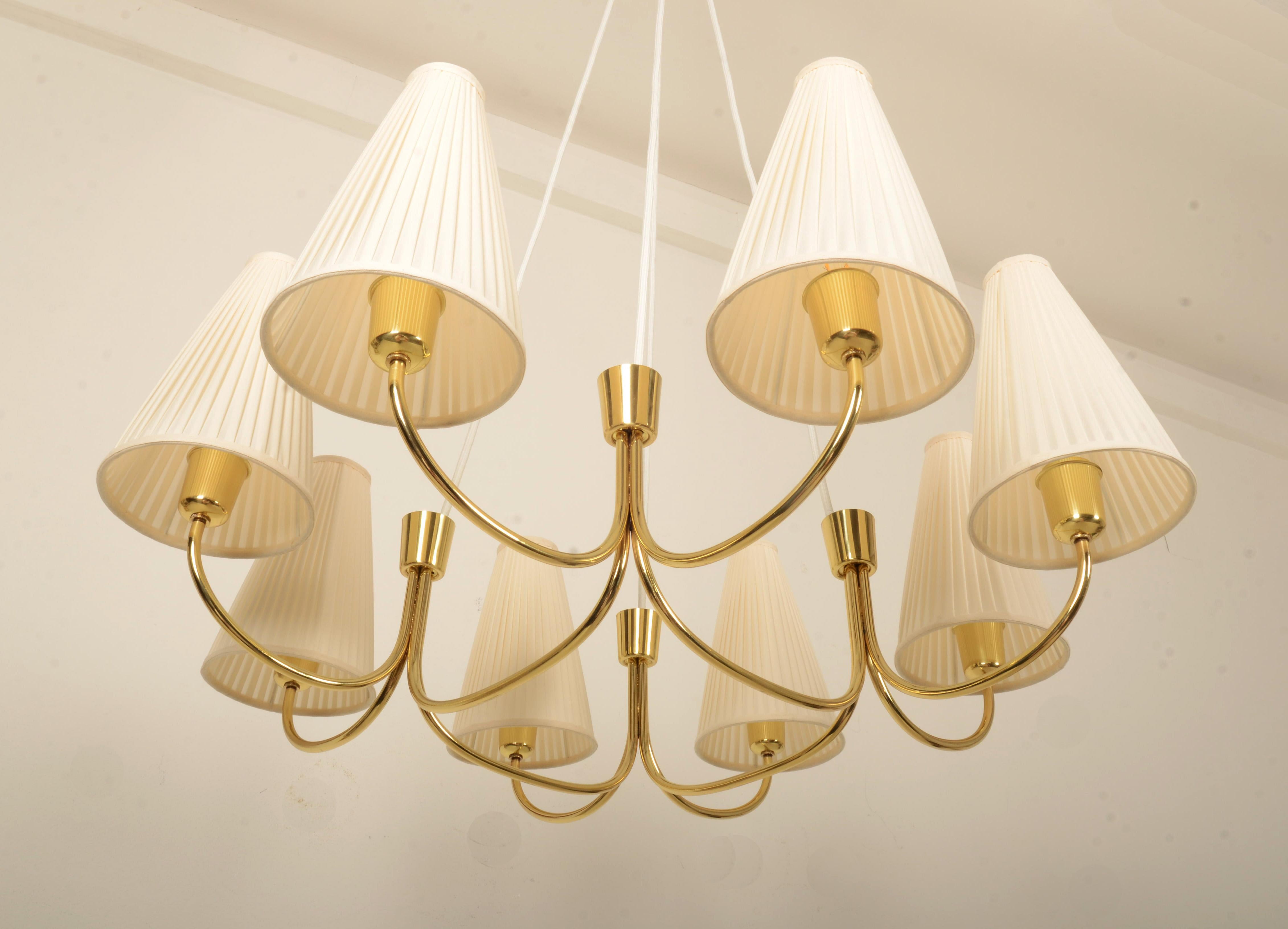 Struttura in ottone con otto bracci e paralumi in tessuto color crema a forma di cono, ciascuno dotato di presa E27. Realizzato a Vienna da Rupert Nikoll all'inizio del 1955. Completamente restaurato con impianto elettrico e tende nuove.
  