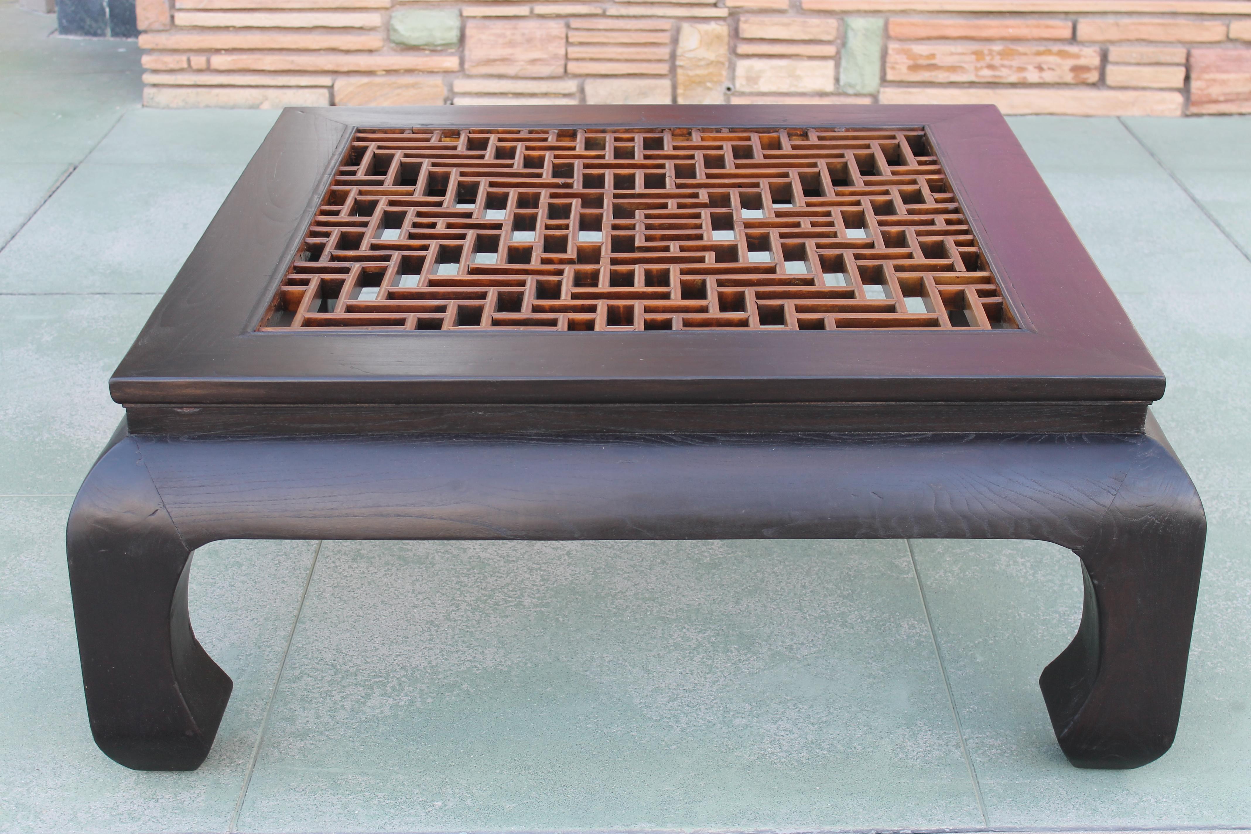 A Ming style table in ebonized oak with handcrafted (with tiny pegs) solid mahogany fretwork. Glass insert measures 30.25