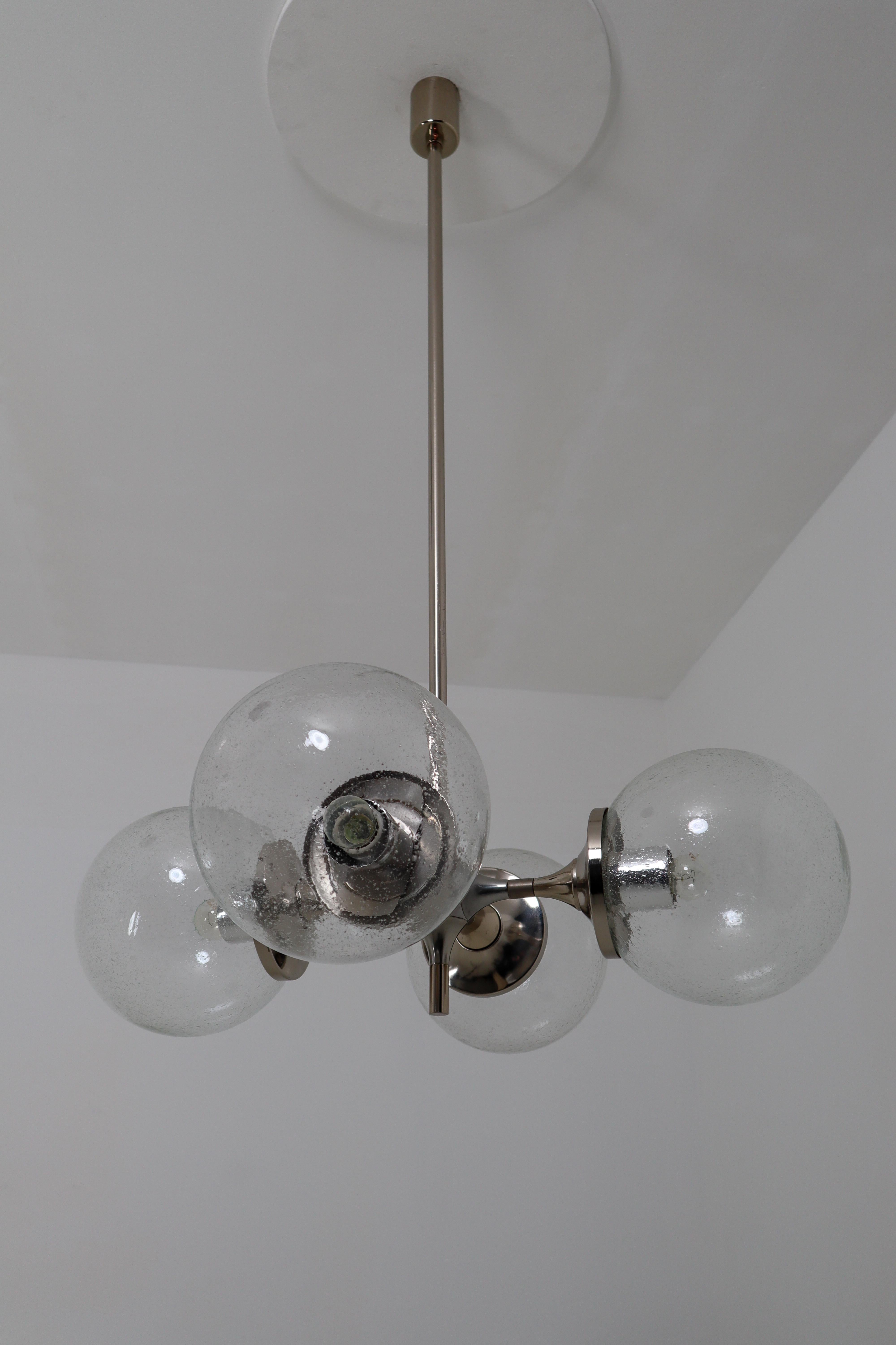 Big modern German chandeliers in nickel-plated steel with beautiful hand blown raindrop glass. Due to the symmetry of the chandelier the light is nicely divided and creates a beautiful light pattern on the wall and sealing. Measures: Diameter 80 cm.
