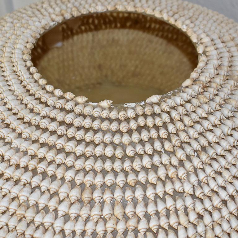 A monumental large seashell encrusted bowl. This unique one-of-a-kind vessel will be a fabulous centerpiece on a dining table or coffee table. Or perhaps even in a foyer. The bowl is wide and low and encrusted with creamy brown seashells. The color