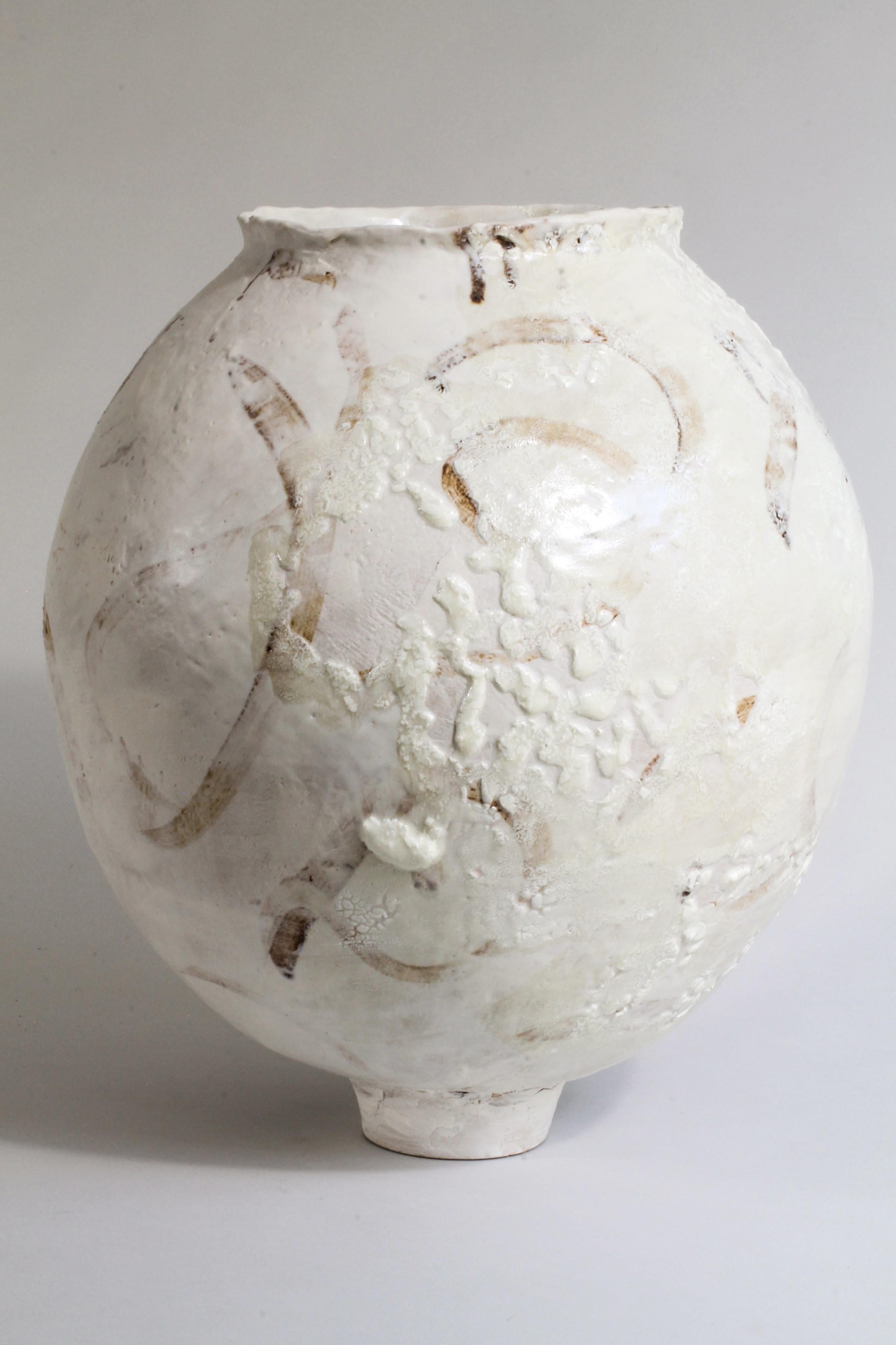 Based on the tradtional Moon jar, this piece has been hand built by Kerry Hastings using the ancient technique of coiling with ropes of clay.  The jar is glazed in a white satin glaze with brushed swirls of manganese and a textured lichen glaze on