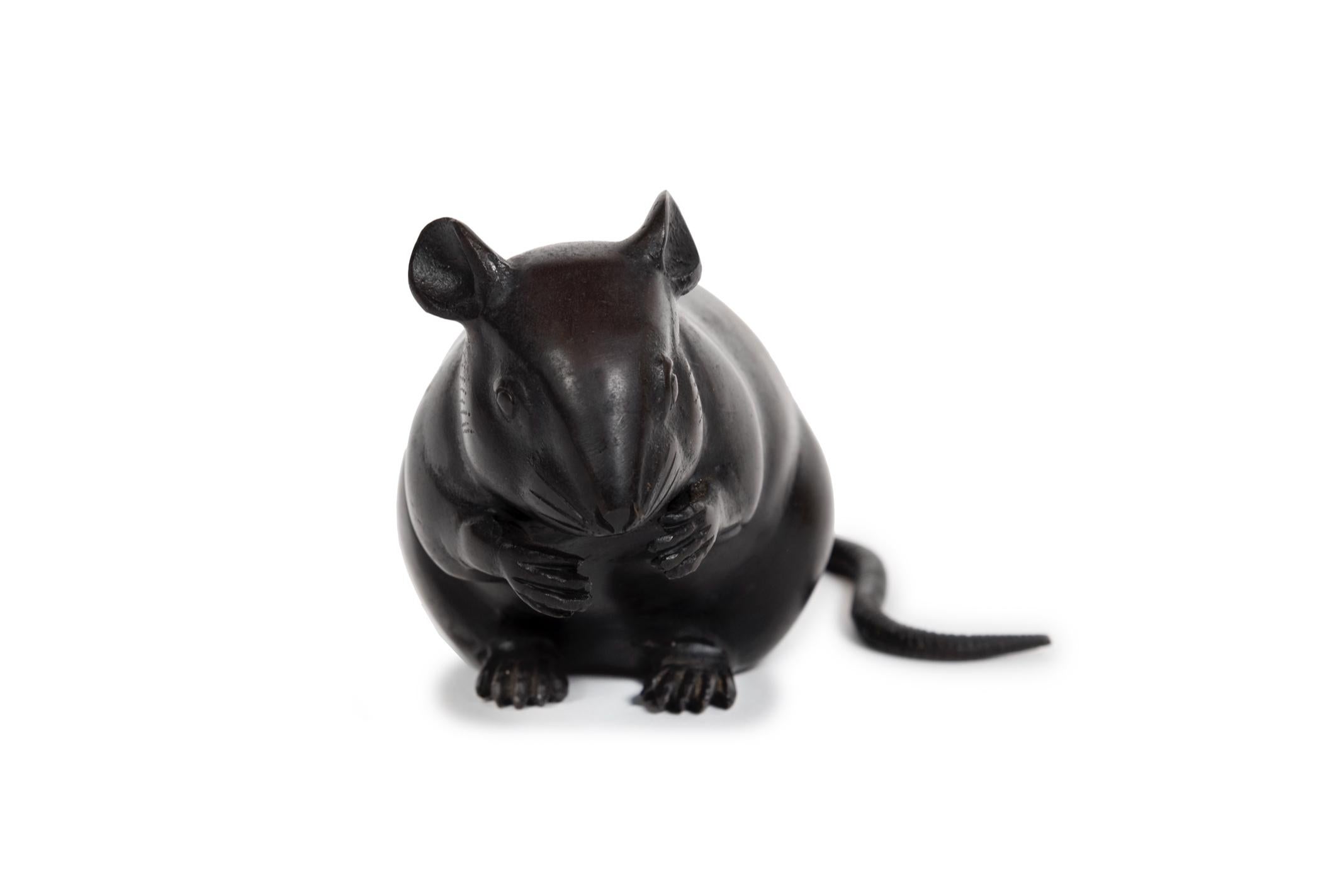 Grande sculpture d'une souris (ou d'un rat), à la patine assez foncée, représentée par un 
expression schématique et réalisée avec la technique du bronze creux. Il est représenté 
dans le prolongement de l'arrière, la tête appuyée sur les pattes