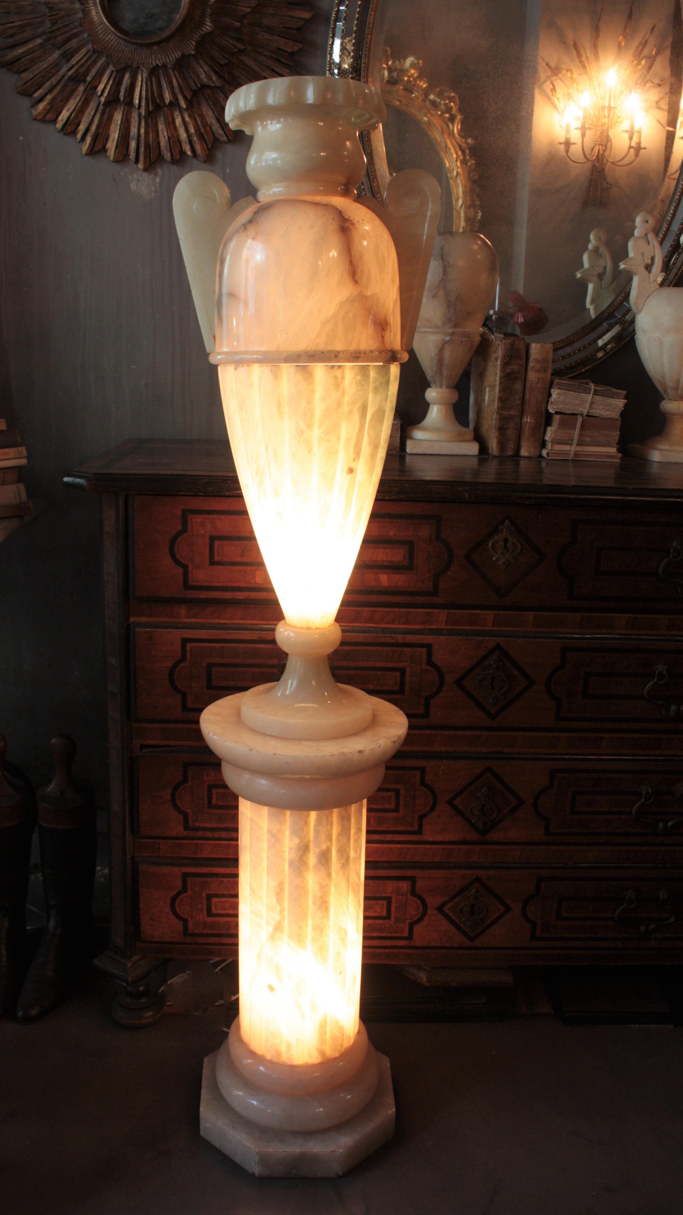 Monumental vase-urne néoclassique en albâtre monté sur un piédestal. Espagne, années 1920-1930.
Cette gigantesque lampe en forme d'urne avec des poignées a un design élégant et une patine d'ancienneté étonnante. Sur un piédestal en forme de colonne