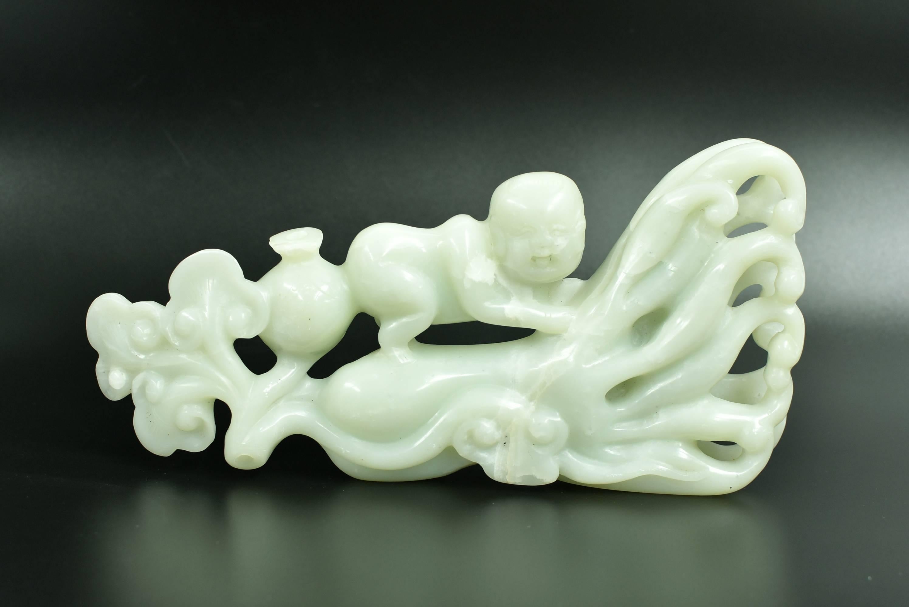 A large, all natural, celadon green nephrite jade sculpture, featuring an chubby baby perched on a citron and lin zhi. The statue has auspicious objects that are symbolic such as citron for great blessings, lin zhi for good health and long life,