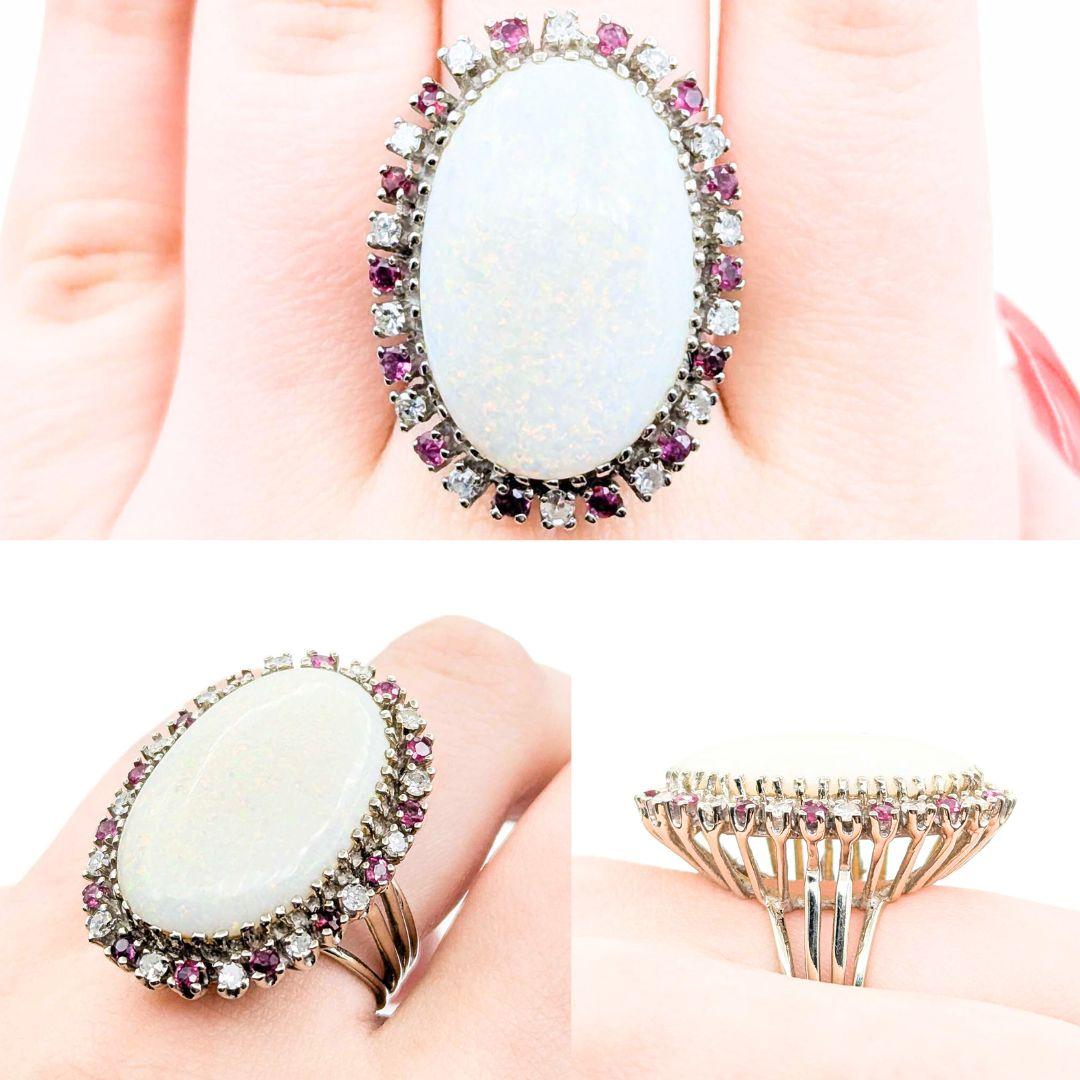 Huge Opal & Diamond Cocktail Ring in 14k White Gold
Introducing this stunning 14k white gold Cocktail ring, featuring a .42ctw diamond, a 13ct Cabochon Opal, and .40ctw rubies. The ring showcases a beautiful diamond and rubies halo design around the