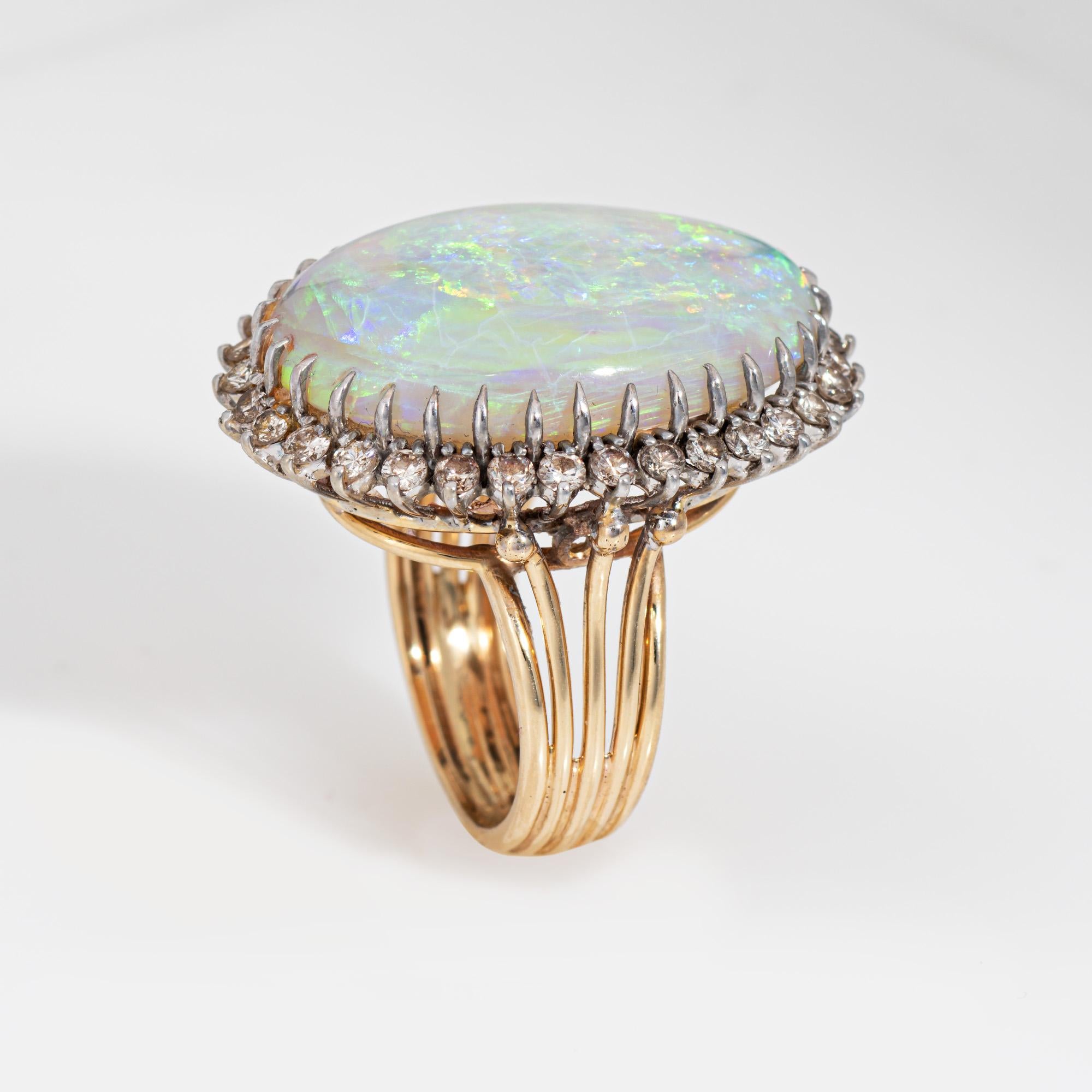 Elegante anello con opale e diamanti in oro bianco 14 carati (circa anni '60-'70).

L'opale naturale tagliato a cabochon misura 25 mm x 16 mm (stima 20 carati). 32 diamanti per un totale stimato di 0,80 carati (colore I-J e purezza SI1-I1). L'opale