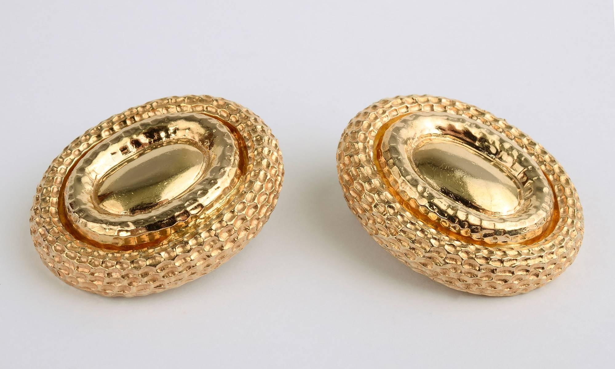 These large, bold earrings make a stunning statement. The smooth inner oval is surrounded by raised ovals of two different textures. They measure 1 3/8 inches in length and 1 1/4 inches in width. Clip backs can be converted to posts.