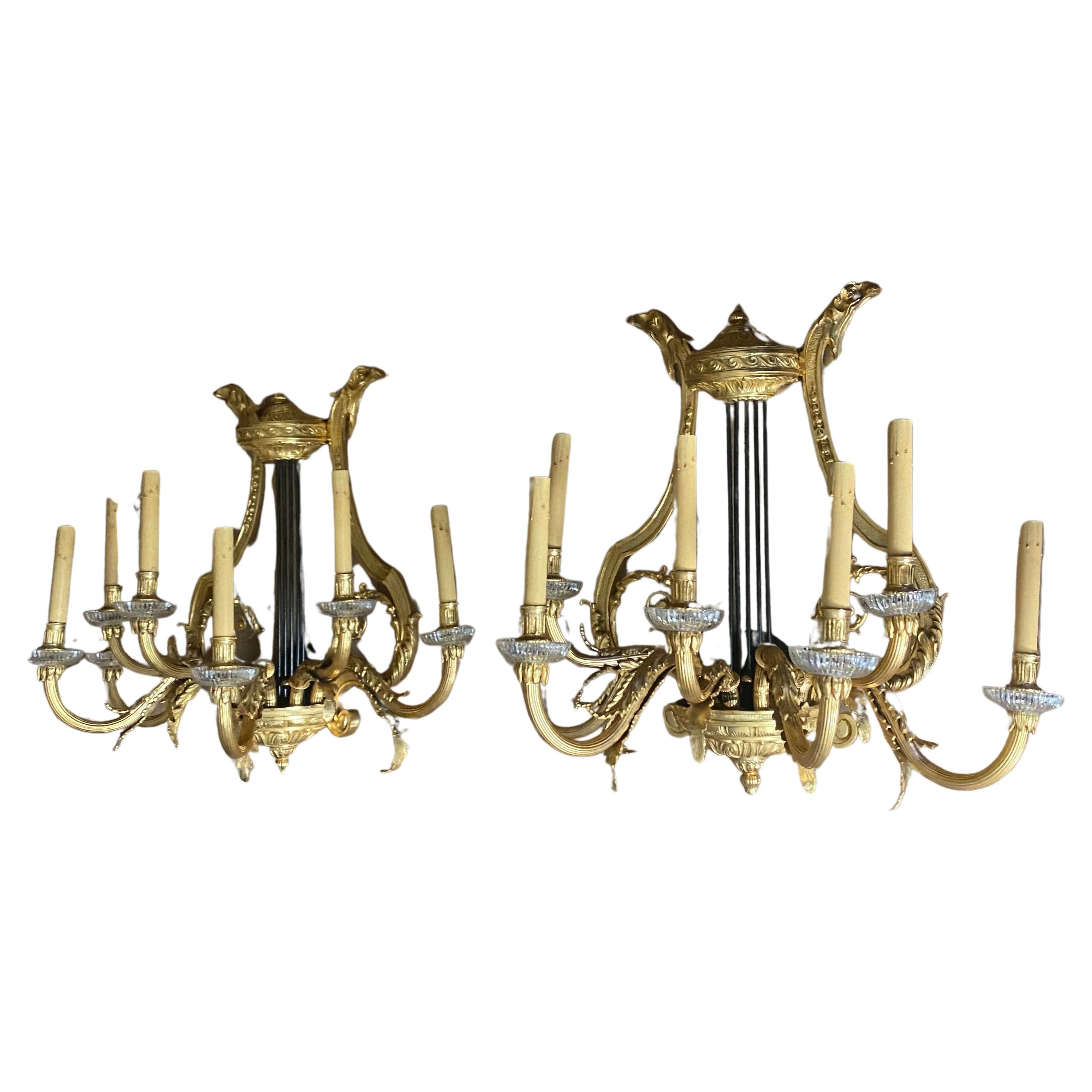 Crafted in the lavish, Louis XV style, these beautiful wall-lights were made in France in the late nineteenth century, and feature seven elegant gilt branches that finish in floral motifs which form the lighting mounts with fluted glass drip