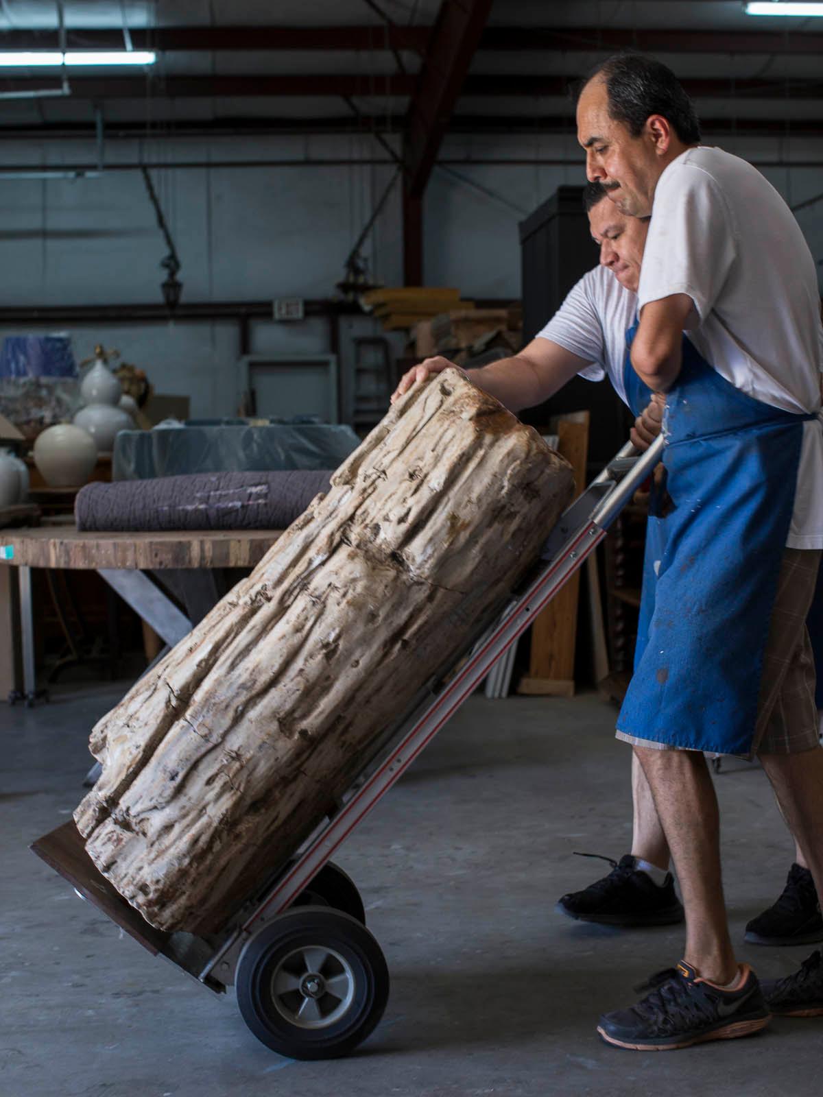 A huge petrified wood tree trunk pedestal column table mounted on a steel stand. This enormous one of a kind slab of petrified wood was excavated from swampland where it remained submerged for thousands of years and slowly absorbed minerals that