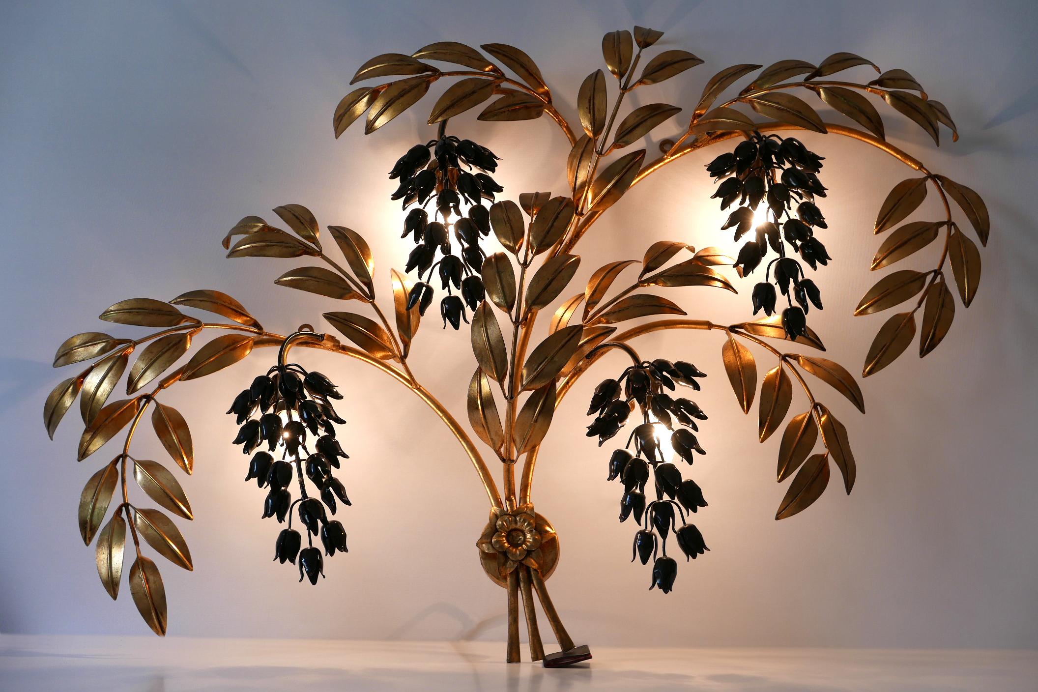 Monumental, four-flamed Mid-Century Modern Pioggia d'Oro wall lamp or sconce. Designed and manufactured by Hans Kögl, 1970s, Germany.

Executed in gilt and partly black enameled metal sheet and tubes, the lamp comes with 4 x E14/E12 Edison screw fit