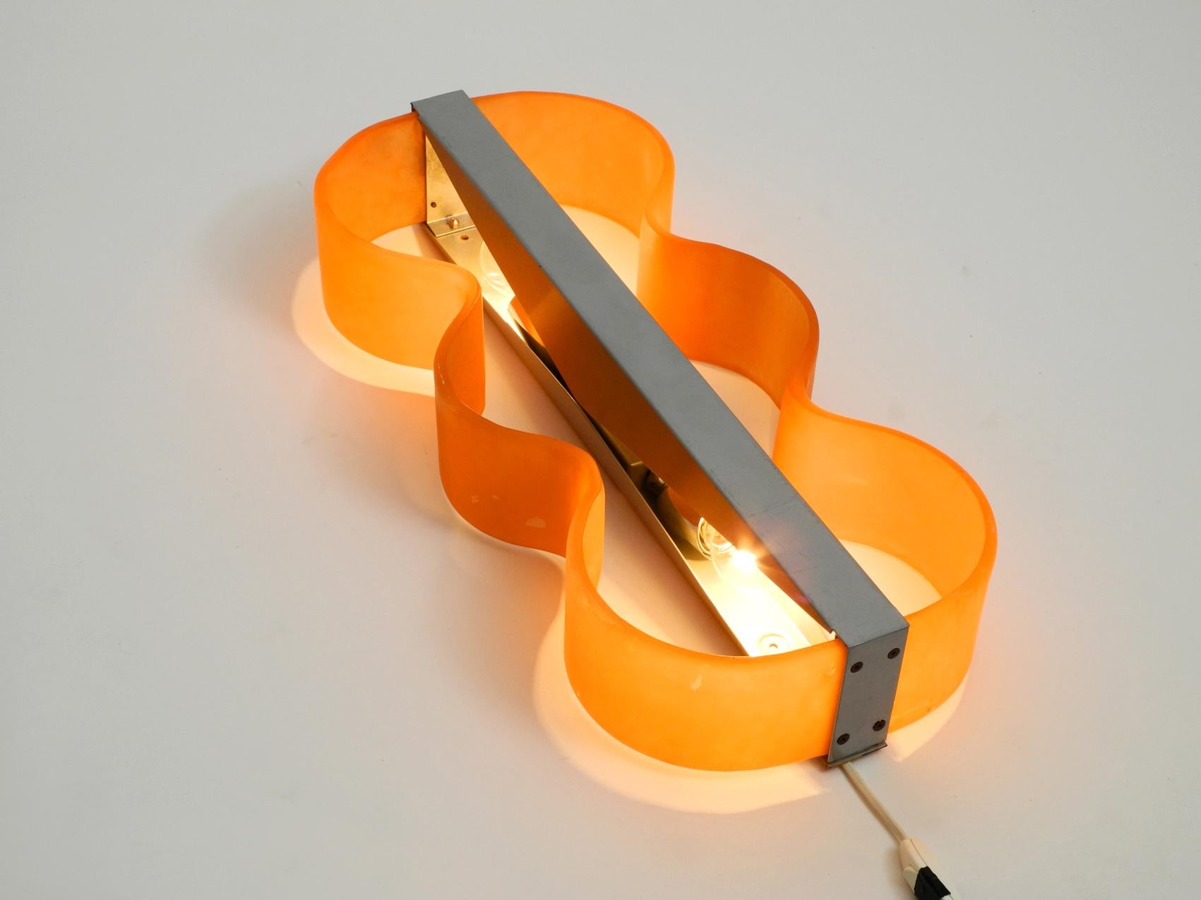 Large heavy glass wall lamp from the 1980s.
Very nice organic design. Probably from an italian production. Creates a very nice pleasant light.
Orange glass in one piece and very solid and heavy.
No cracks or chipping on the glass shade.
But some
