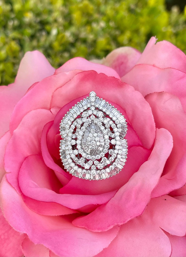 Ravishing, very large and stately, 15 carat diamond cocktail ring set in 18 karat white gold, features a domed pear shaped ballerina center of baguette and round brilliant diamonds surrounded by a beautiful open halo of diamonds set and arranged in