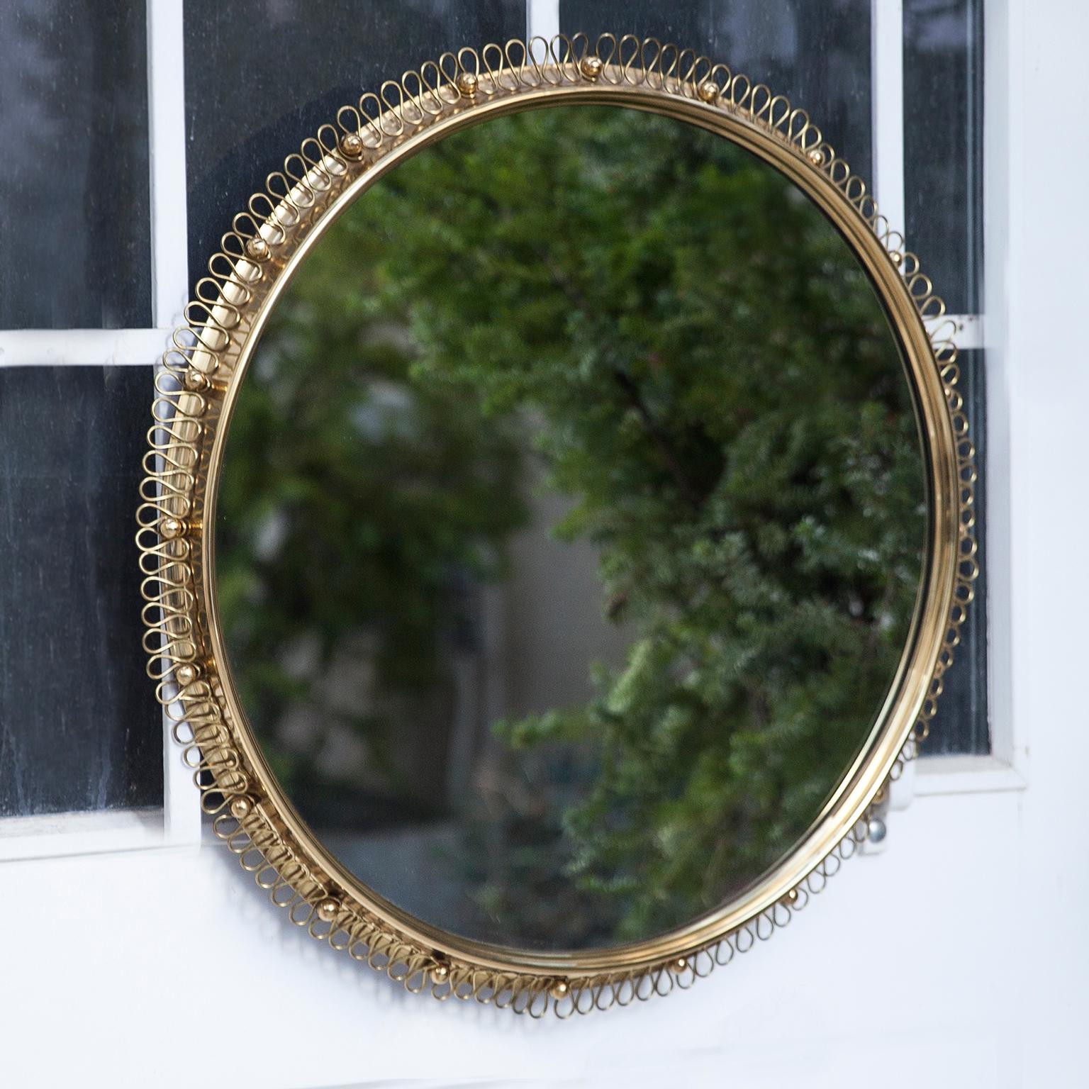 A beautiful mirror with a nice brass loop frame and a decorative brass ring from the 1950s. Designed by Josef Frank for Svenskt Tenn, Sweden.