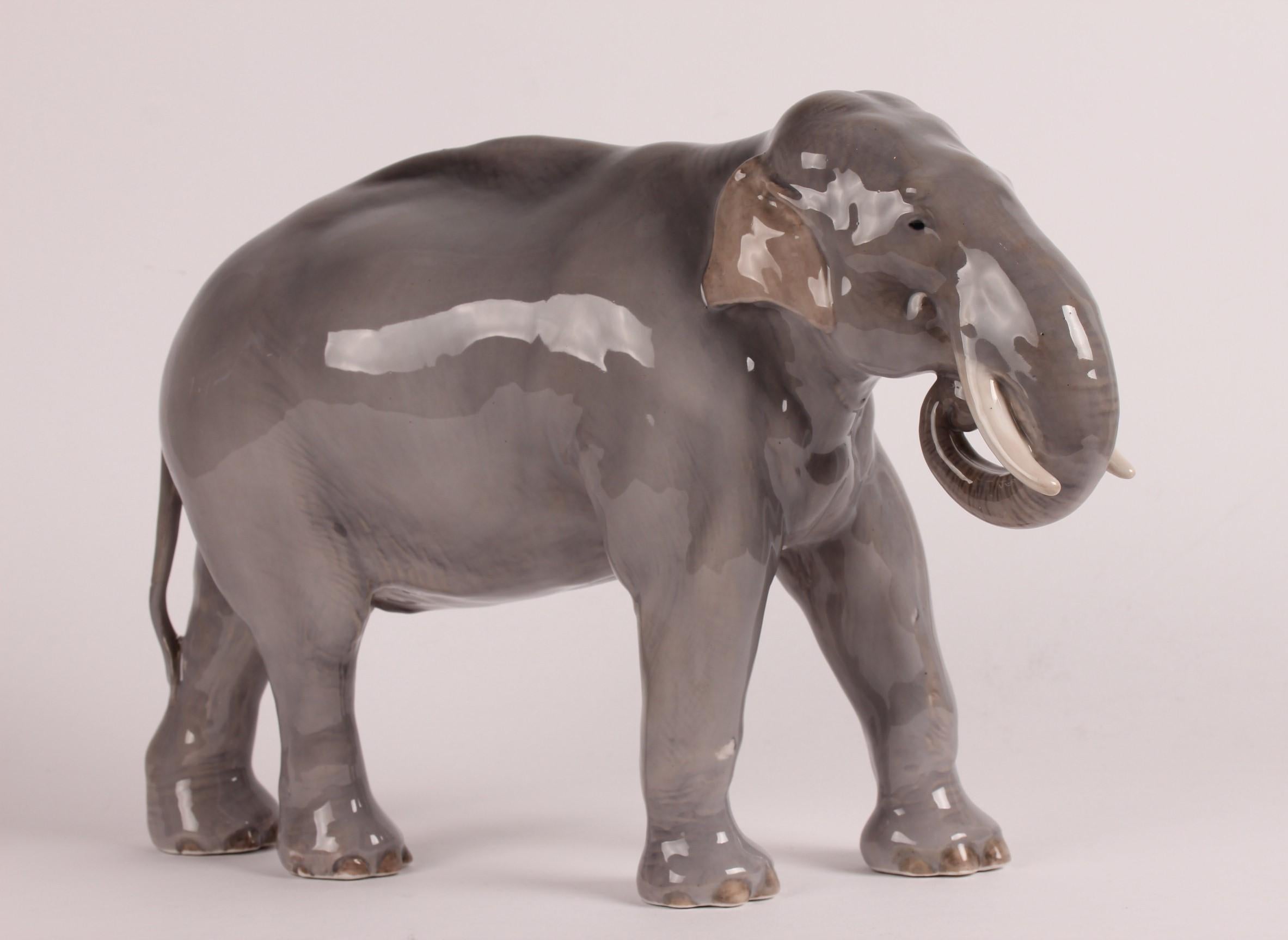 Huge Danish porcelain figure of an elephant model 447 designed by Theodor Madsen and manufactured by Royal Copenhagen.

The figure is decorated with glossy glaze in grey, brown and creamy white colors

Stamped with the three waves of Royal