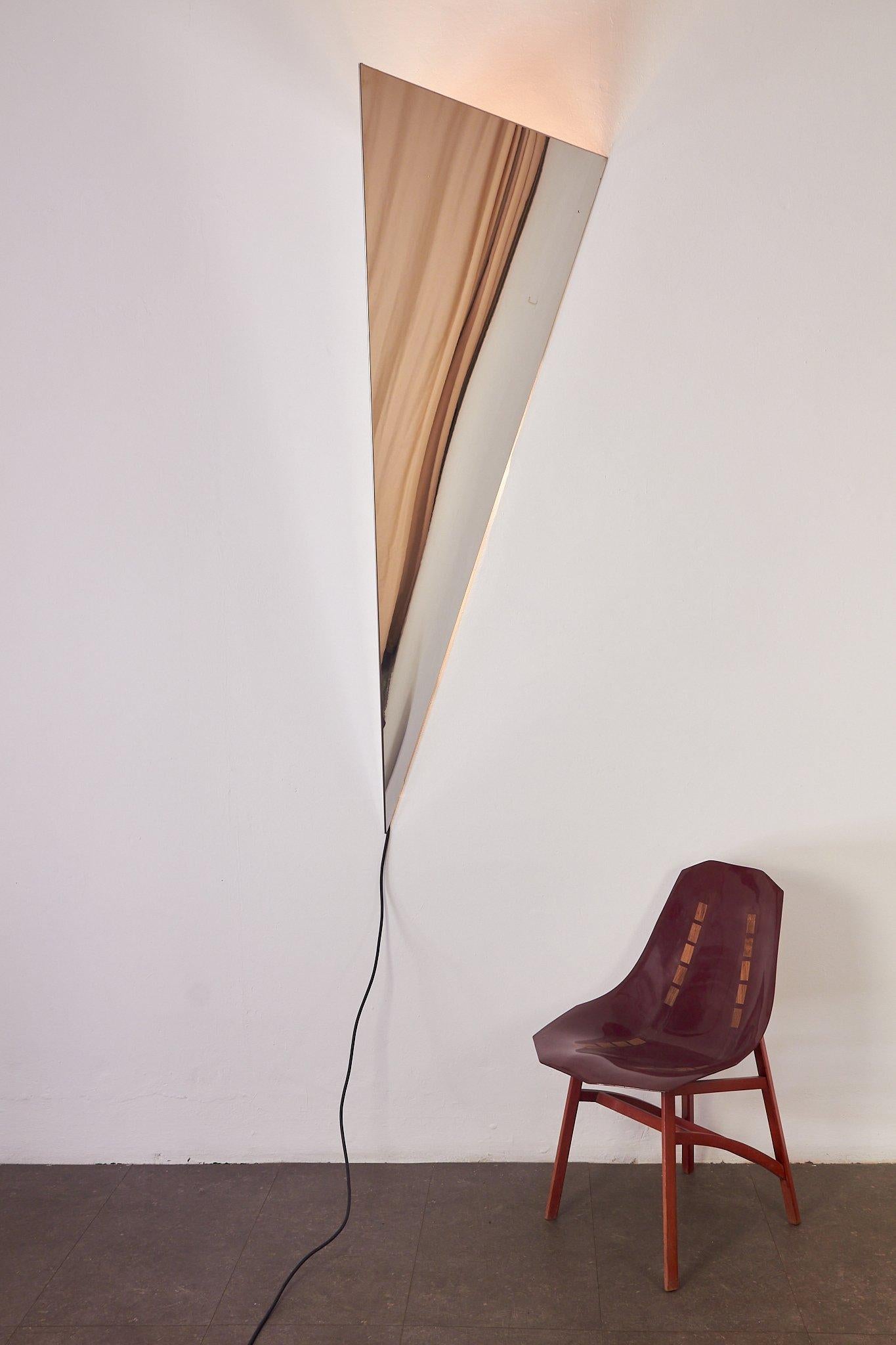 Lampada in metallo cromato a forma di piramide, possibile sia appenderla a muro sia lasciarla sul pavimento.
Grande lampada per chi vuole una lampada scultura spaceage, che faccia anche da specchio oltre illuminare la parete.
produzione italiana