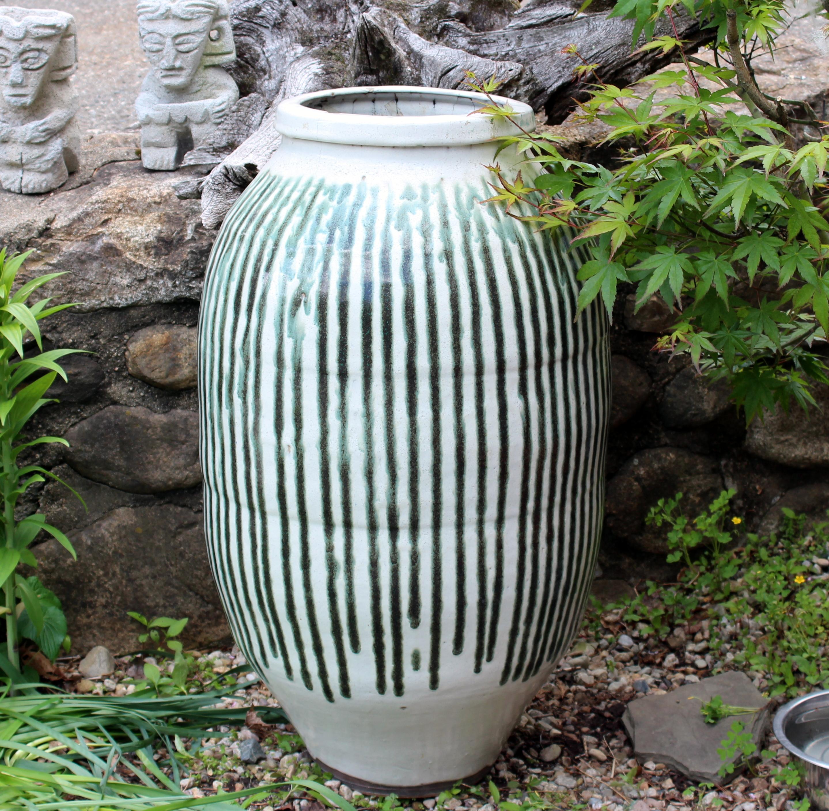 Huge antique Shigaraki wine or water storage jar with Hagi-Nagashi glaze, circa 1900. Nice, organic form with copper green stripes. Measures: 34