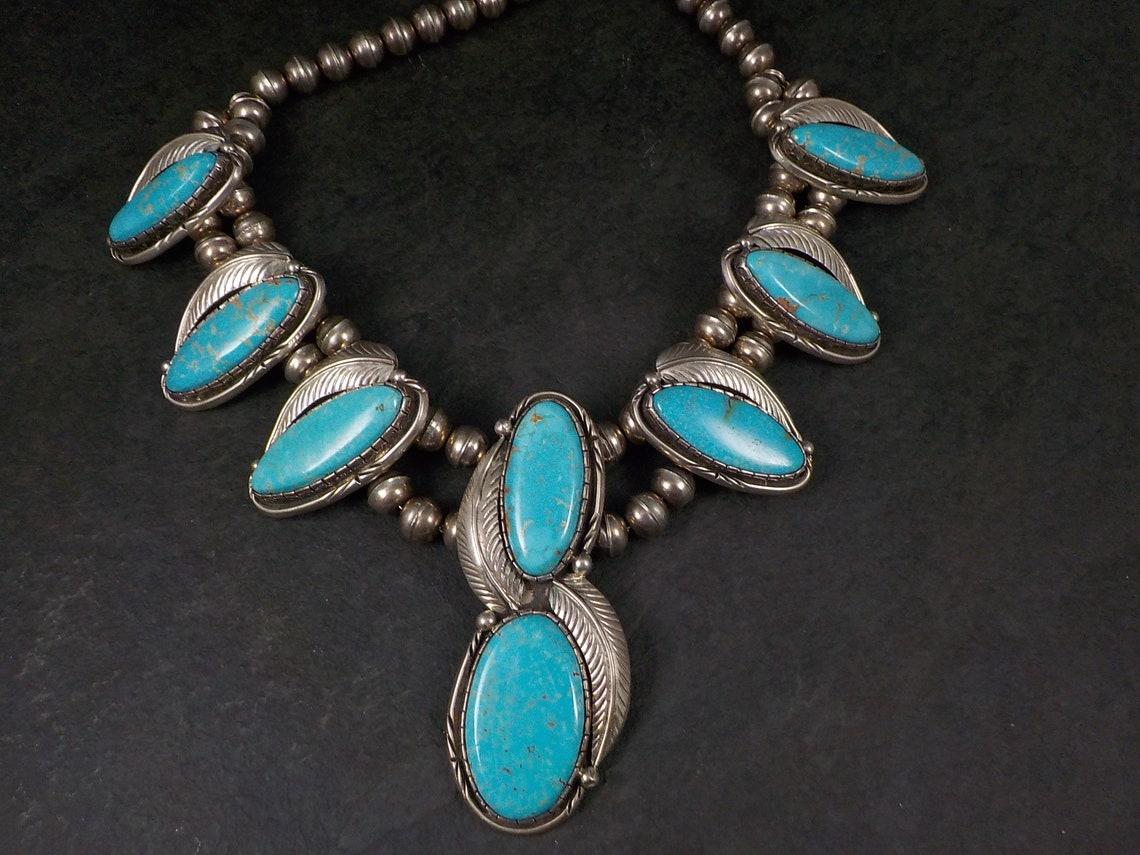 This gorgeous vintage necklace is comprised of sterling silver and natural turquoise.
It is the creation of the late Navajo silversmith Fred Guerro.

This necklace measures 21 inches end to end and 13 inches when clasped.
It features 6 smaller
