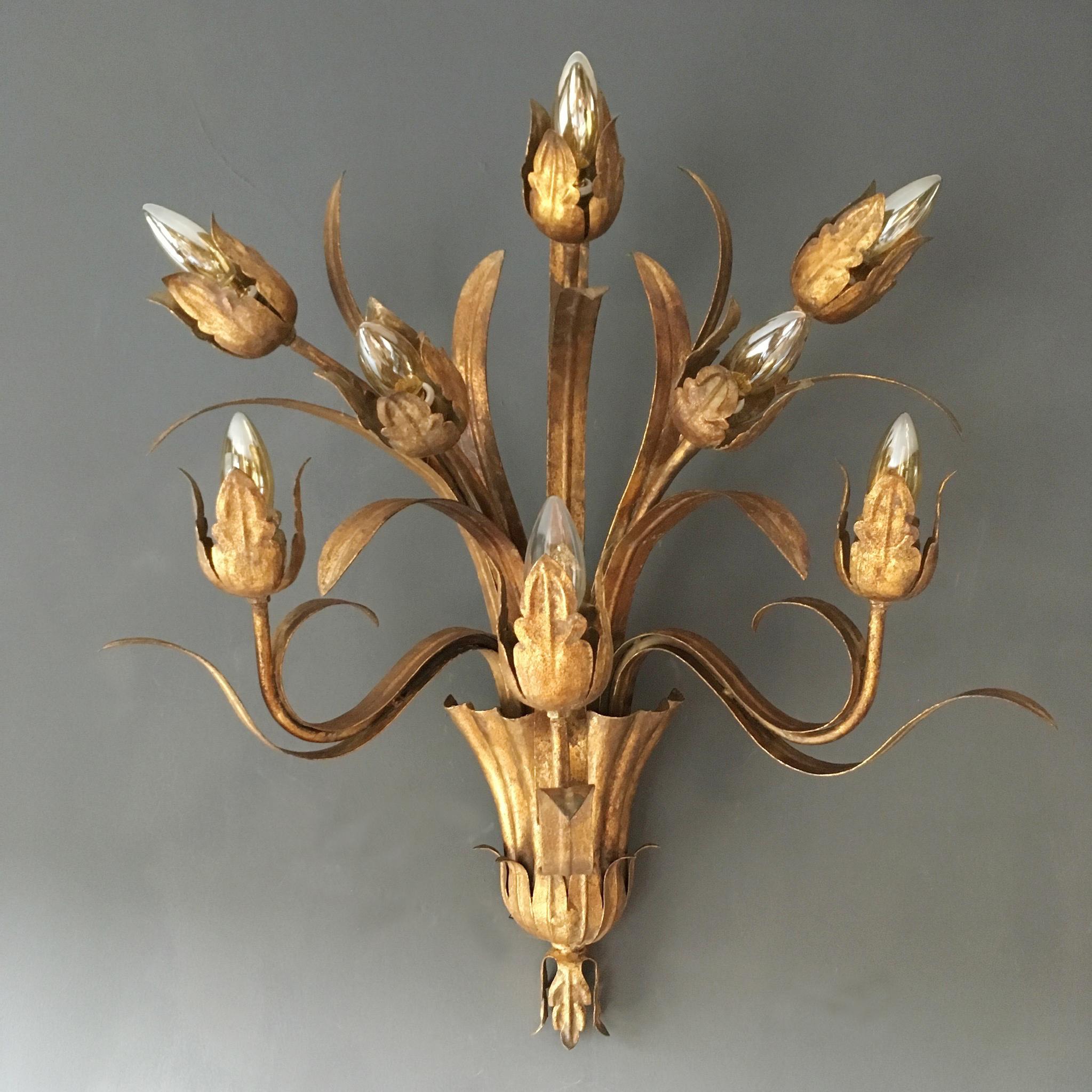 Huge Spanish flower bud wall sconce.

This is a very large and heavy wall sconce, made from gilt iron it weighs 3.5kg.

Dimensions:
75cm height
61cm width
41cm depth.

The design is beautiful with 8 large flower buds/tulips reaching up