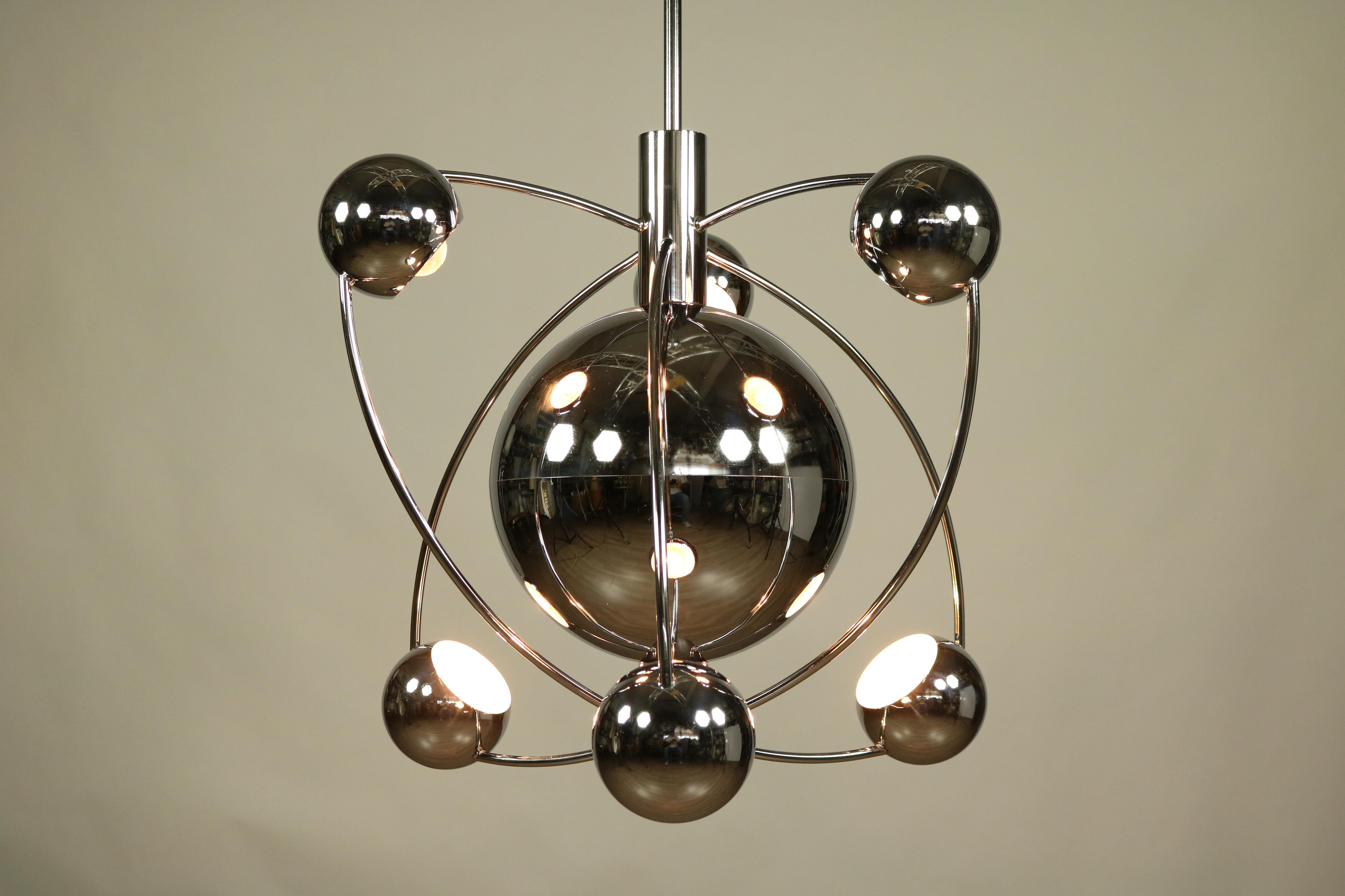 Extra large Space Age Design pendant lamp made of chromed steel and brass
the design reminds to a big planet in the center which is circled by 6 moons
or an atomic nucleus is orbited by 6 electrons !
Measures:
Diameter of the ball into the