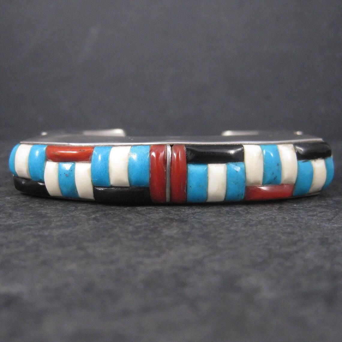 This gorgeous vintage cuff bracelet features gemstone inlay in red, white and blue with just a touch of black jet.
This piece is heavy, stunning and huge. Definitely not a bracelet for the faint of heart.

The face of this bracelet measures 1/2 of
