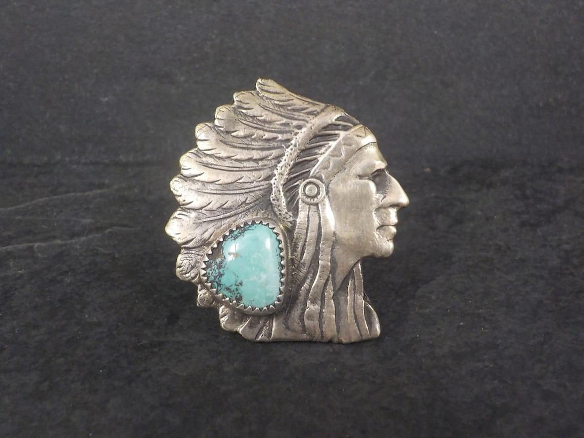 This huge, stunning chieftain ring is sterling silver with an 11x13mm natural turquoise stone.

It is the creation of Navajo silversmith Curtis John.

The face of this ring measures 1 1/2 inches east to west and 1 11/16 inches north to south.

Size:
