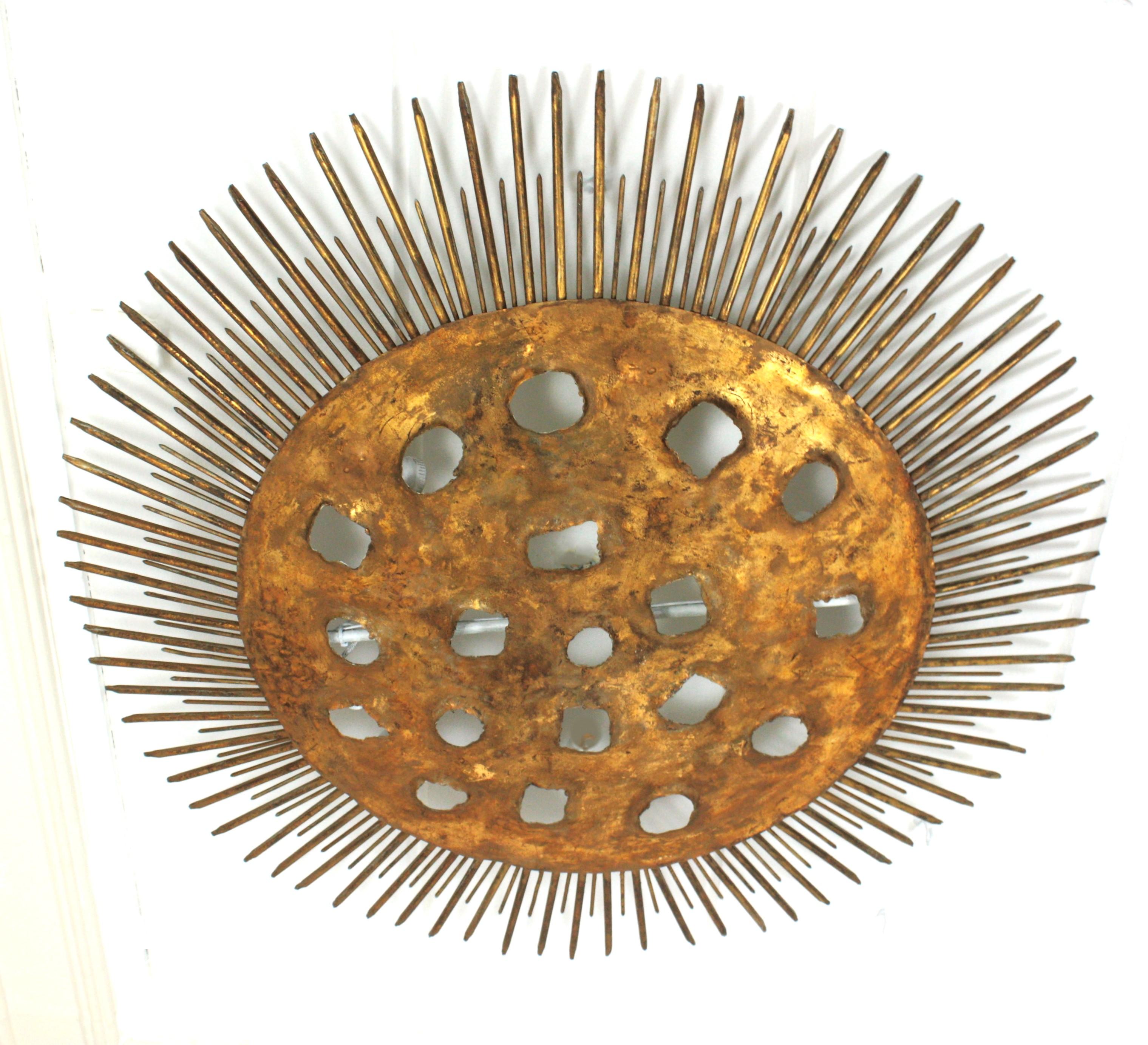 Monumental Brutalist Sunburst Flush Mount, Wrought Iron, Gold Leaf
XXL Sunburst light fixture with perforated holes at the central plate and nail details. Spain, 1950s.
One of a kind hand-hammered gilt iron sunburst ceiling light fixture or wall