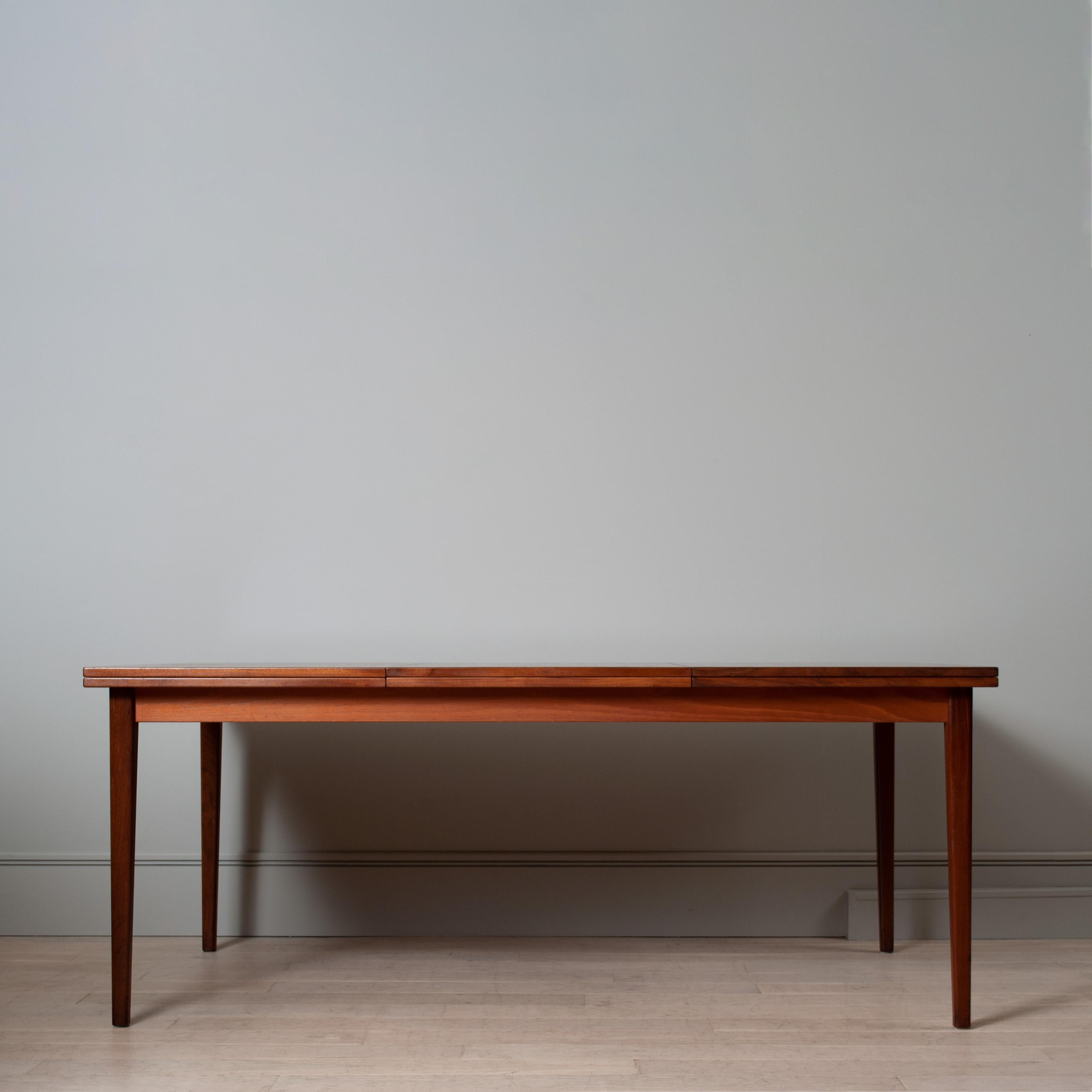 A huge Swedish streamlined teak double extending table - with a significant length of 3m when fully extended. 
This is a versatile, solid and robust modernist design table with a smooth and genius sliding operation. The solid brass hinged flip open
