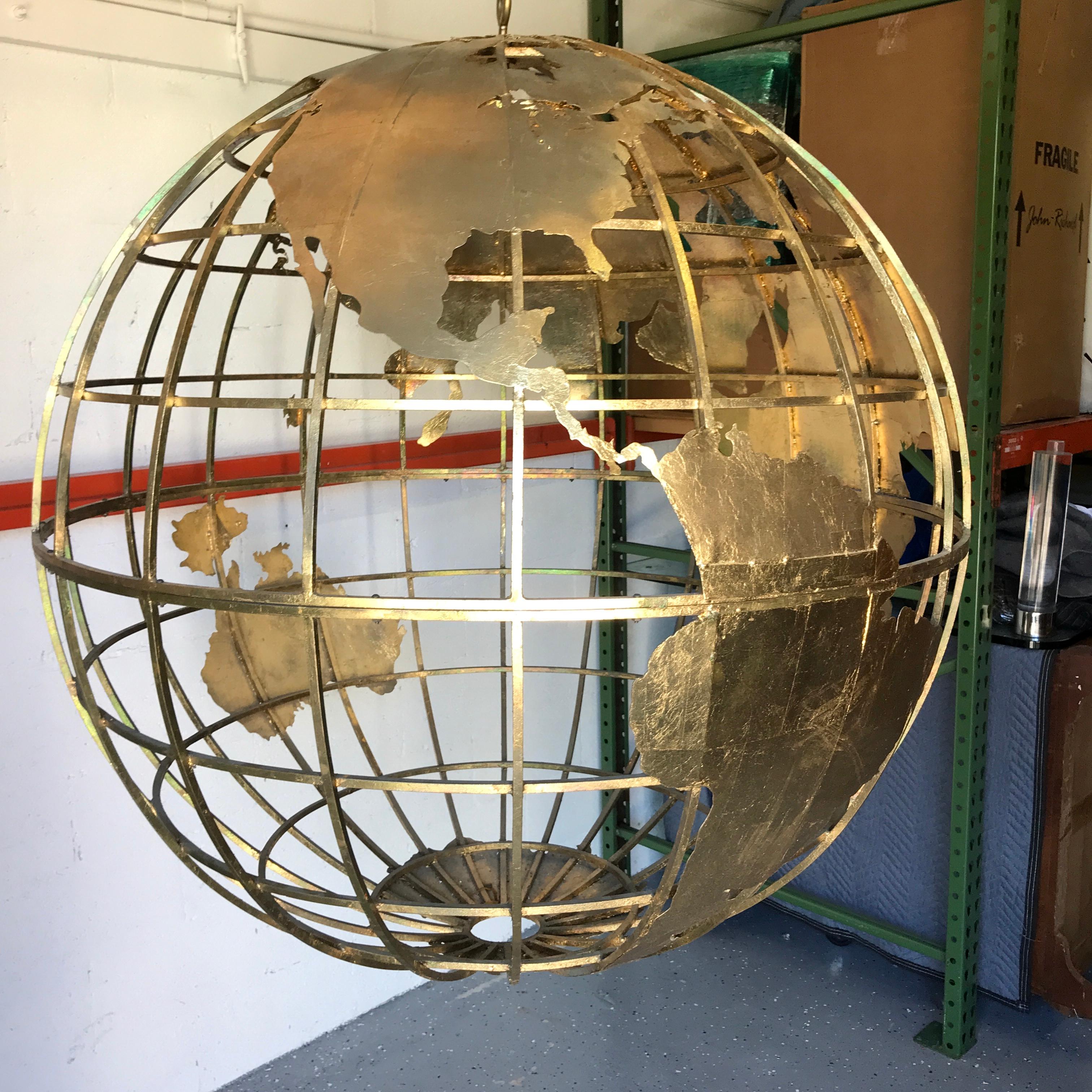 Huge three dimensional gilt metal world globe sculpture, complete with 5 feet of gilt chain. 
