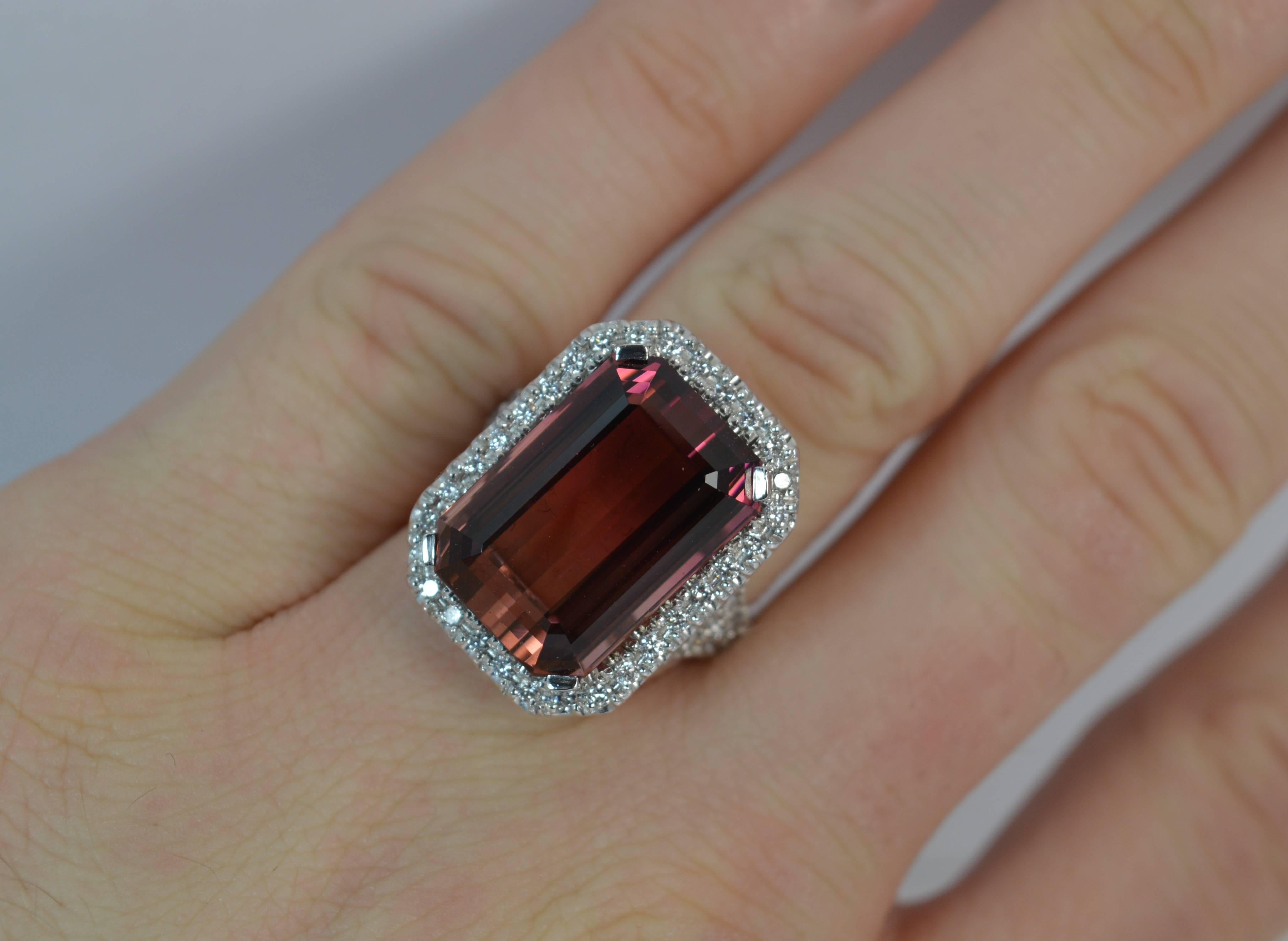 Set with a large natural emerald cut tourmaline to the centre with a full border of round brilliant cut diamonds surrounding and further diamonds set to the shoulders.


CONDITION ; Excellent. Well set stones. Polished, clean band. Looks unworn.