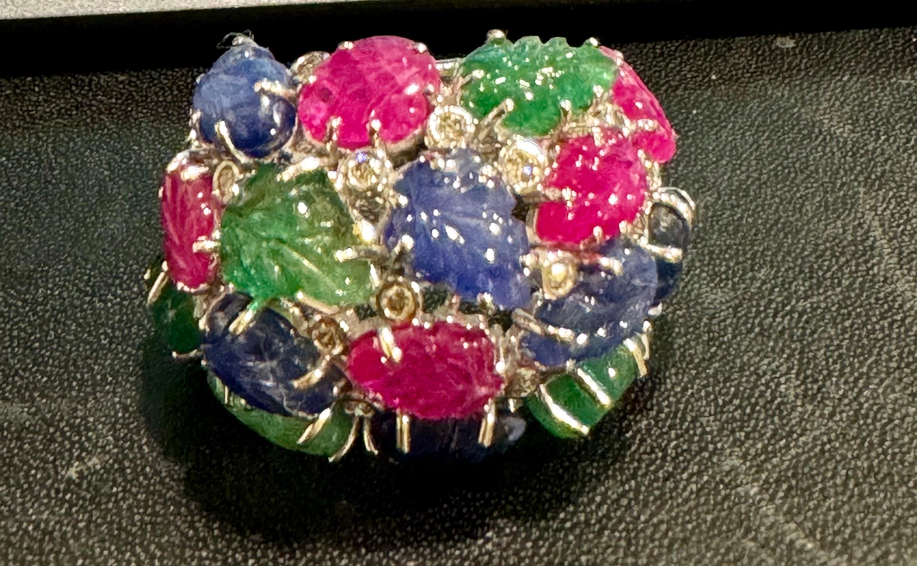 Der riesige Tutti Frutti 18K Ring, verziert mit Smaragden, Rubinen, Saphiren und Diamanten in Größe 9, ist ein seltener Fund mit exquisit geschnitzten Edelsteinblättern. Aus den 1920er-1930er Jahren stammend, wurde diese Art von Schmuck vorwiegend