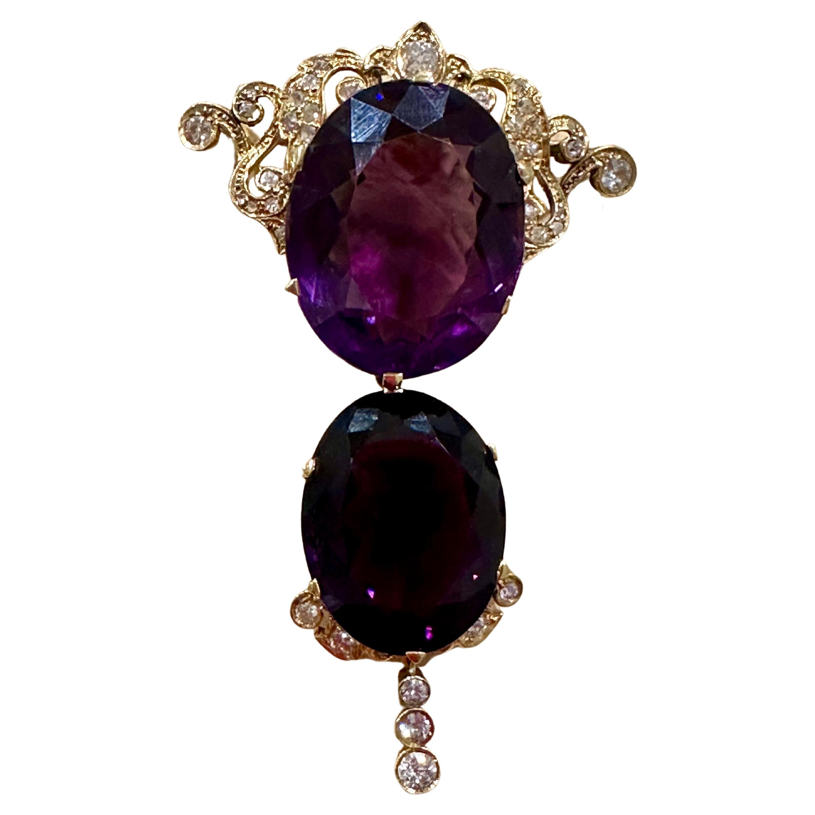 This spectacular pendant necklace/pin consists of two large perfect pear-shaped amethysts, totaling approximately 70 carats. The amethysts are set in a gold frame with diamonds, adding to its elegance and beauty. This is a vintage piece with