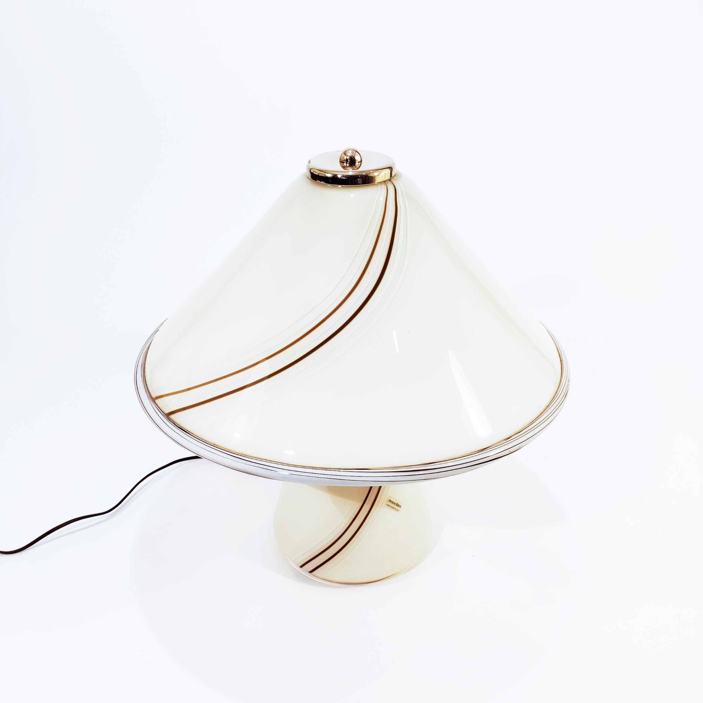 Large Italian table lamp made of thick Murano glass, manufactured by Venini in the 70s, Venice. Mushroom-shaped, handcrafted in soft cream-tone glass with swirling details in white and brown. Structure and details in gold chromed steel metal and