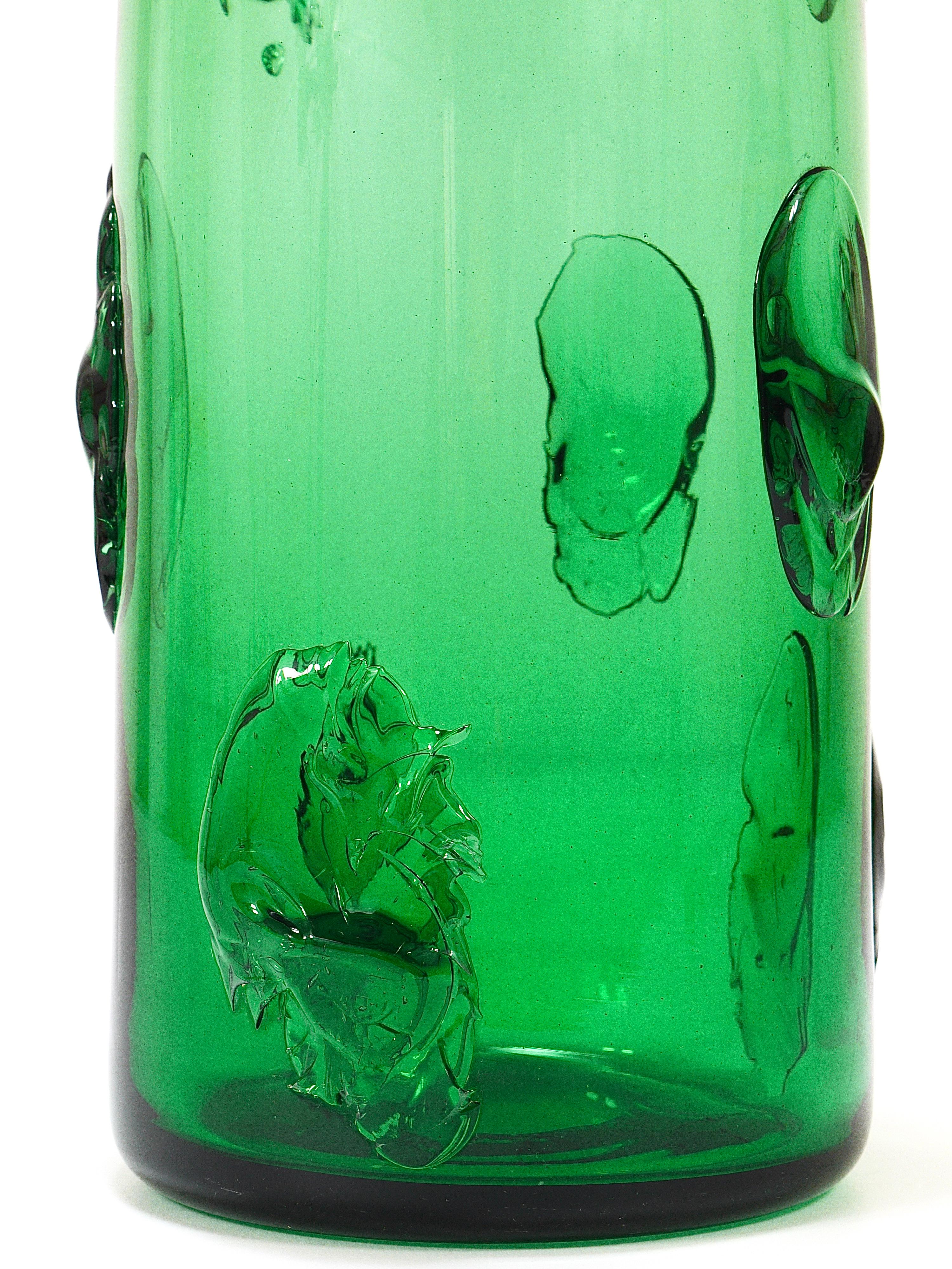 A beautiful and large Italian Vetrerie di Empoli vase from the 1960s, hand-blown from thick vibrant emerald green glass. The vase has a round base and a square top and hot-applied decoration to its surface. It is 12 1/2 inches high and has a