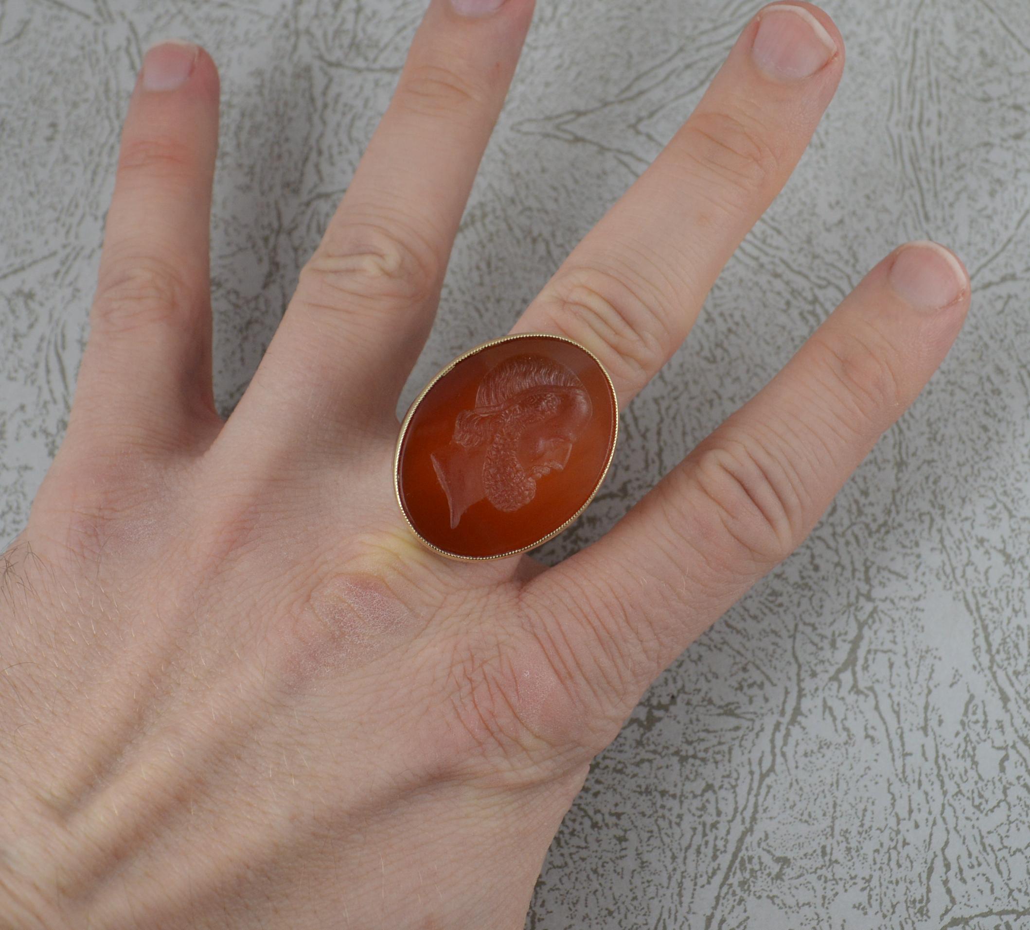 A Victorian era intaglio seal signet ring.
Solid 9 carat gold example, great size.
Oval shaped carnelian  to centre. Depicting a bust of a male figure.
23mm x 30mm stone.

CONDITION ; Very good. Clean solid shank. Well set carnelian, issue free. A