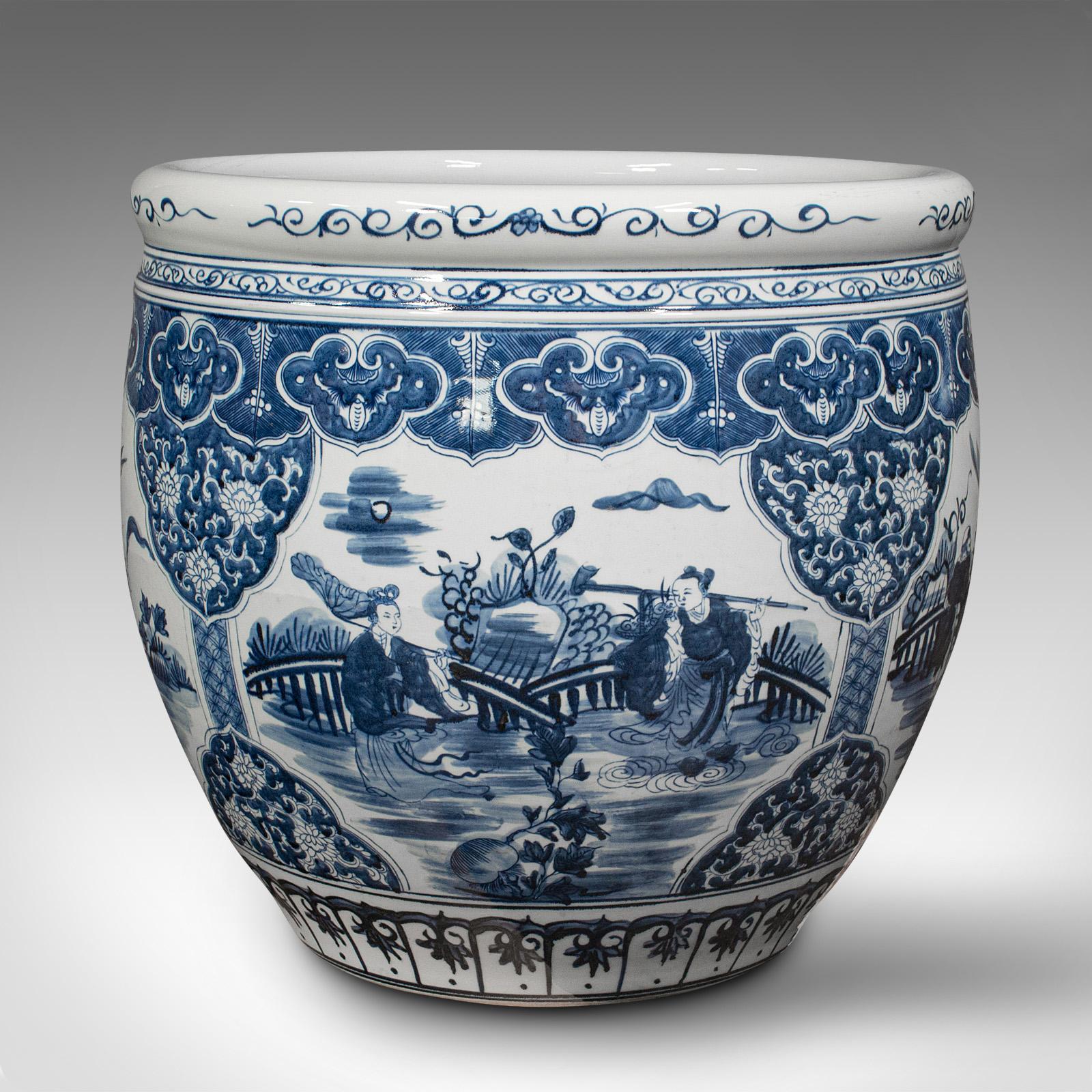 This is a huge vintage decorative planter. A Chinese, ceramic jardiniere pot with classic white and blue decor, dating to the late 20th century, circa 1980.

Impressive proportion with a large canvas for the decorative Oriental panels.
Displays a